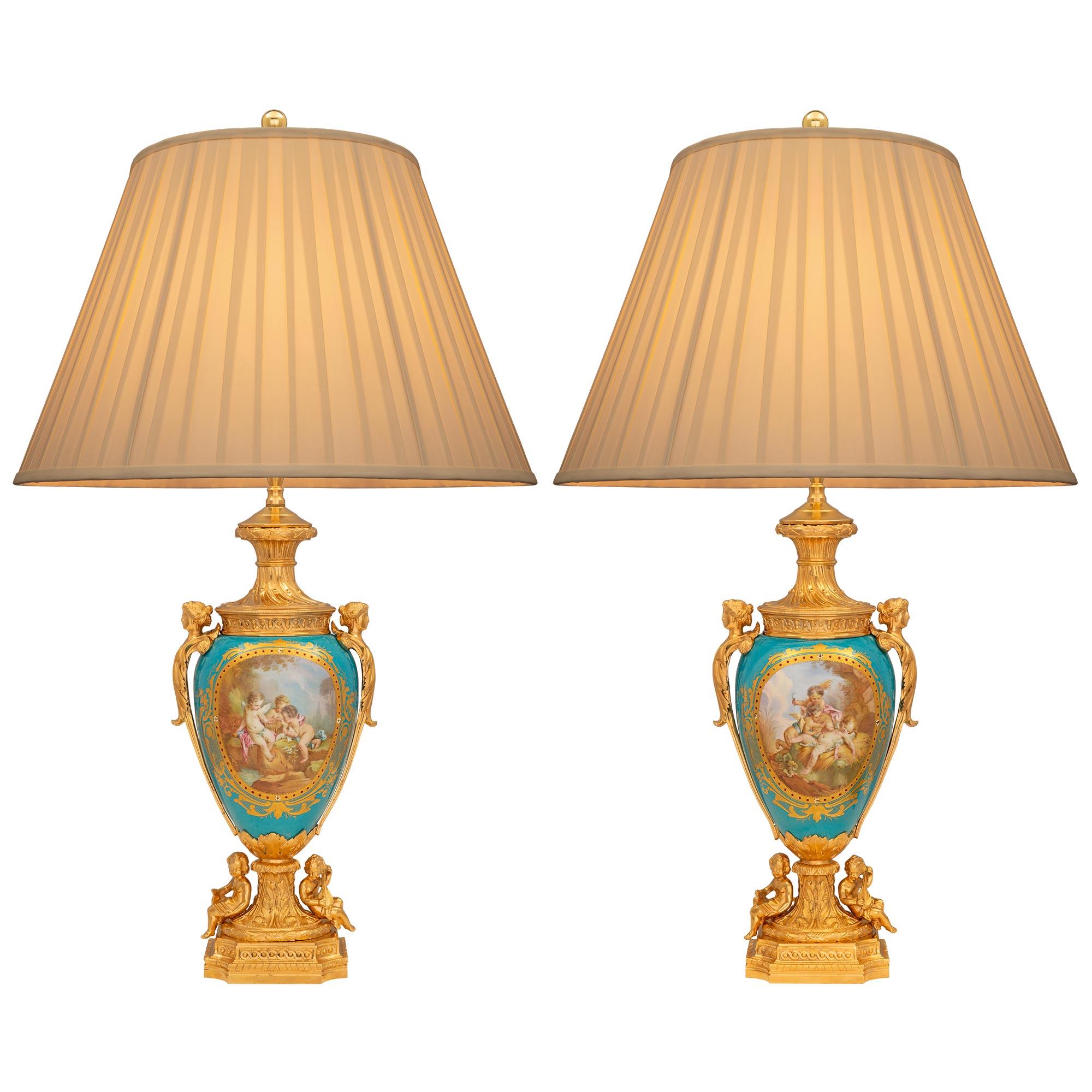 Une belle et très élégante paire de lampes françaises du 19ème siècle en bronze doré et porcelaine de Sèvres. Chaque lampe est surélevée par une remarquable base carrée en bronze doré, avec de fins motifs marbrés en gradins, des coins concaves et de