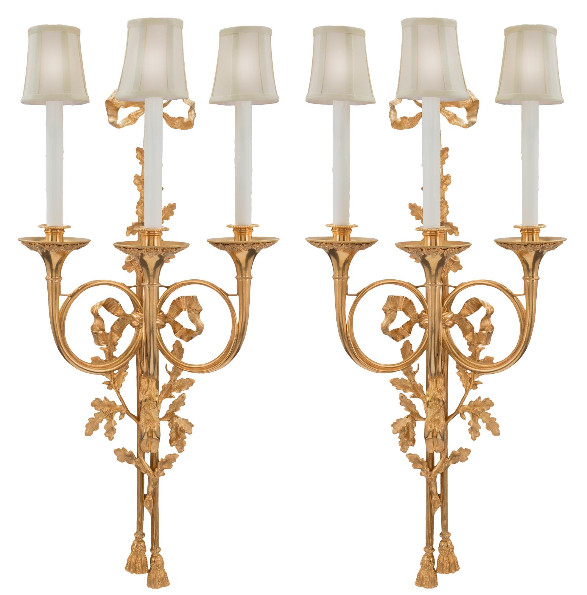 A pair of French 19th Century Louis XVI st. ormolu three arm sconces