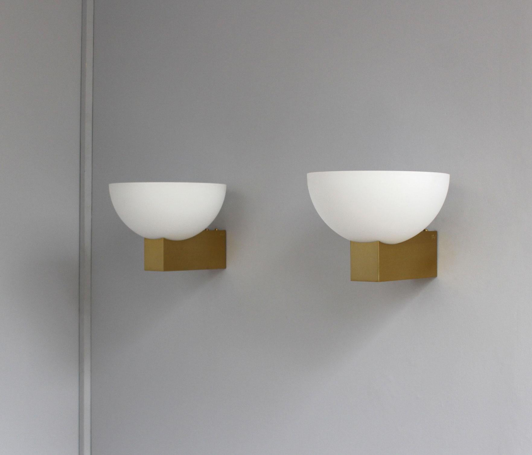 Atelier Perzel – A pair of fine French Art Deco wall lights with a enameled white glass bowl shade sitting on a bronze frame.
  