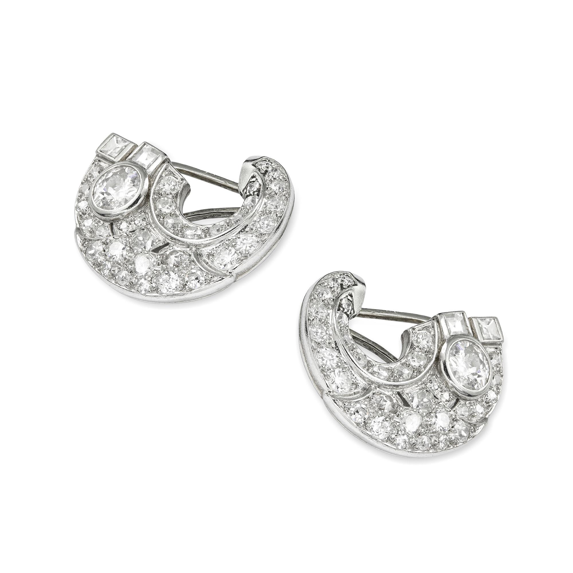 A pair of French Art Deco diamond-set scroll ear clips, each in the form of cornucopia, set throughout with old brilliant-cut and carré-cut diamonds, the diamonds estimated to weigh 3.5 carats in total, all grain and rubover-set in platinum, on peg