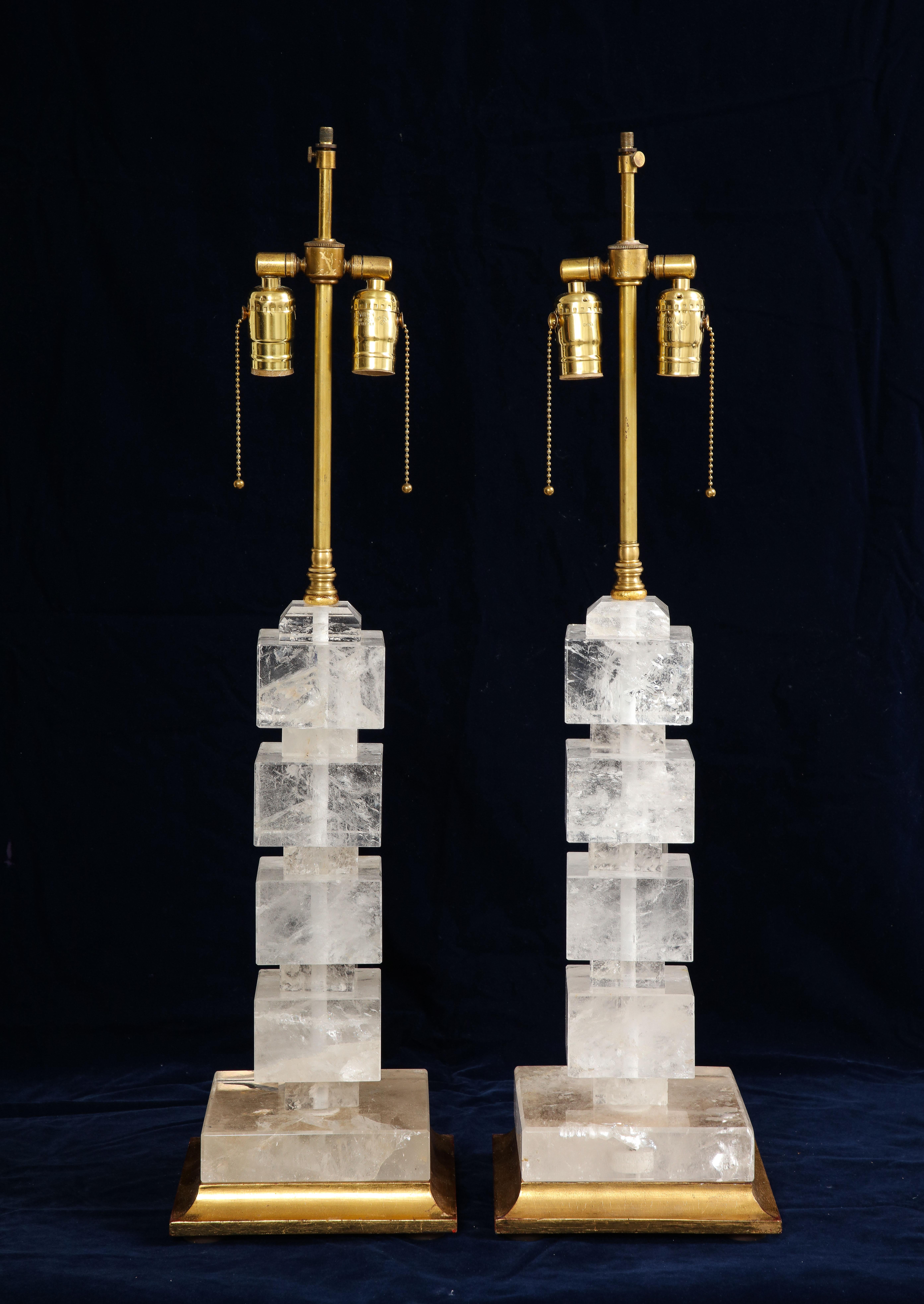 A Pair of French Art Deco Period Rock Crystal and Giltwood Square Lamps.  This stunning pair of lamps is a beautiful example of the Art Deco style, popular in the early 1900s. The lamps feature a gilt wood base that flares out towards the ground.