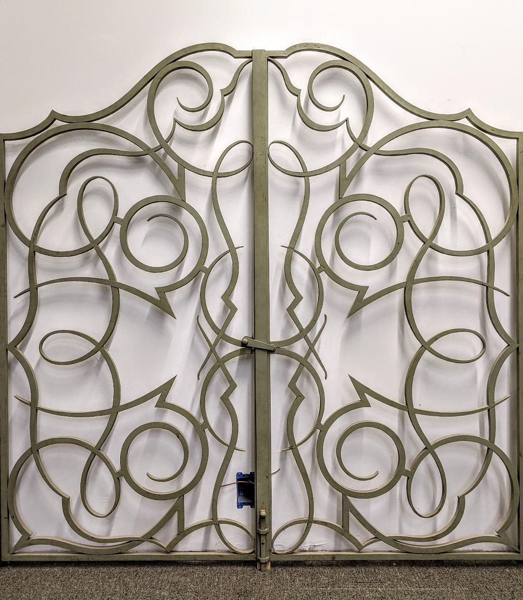 A French Art Deco wrought iron set of double-sided doors, gates, or screens. Each side consists of two separate sections that are attached by hinges with a center latch. We are the rare source that has specialized exclusively in French Art Deco for