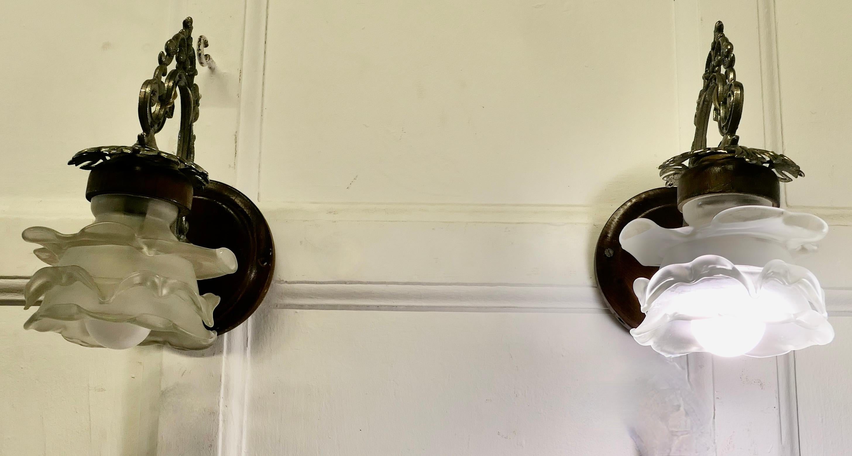 A Pair of French Arts and Crafts Wall Lights with Flower Shades

The Lights have very decorative silvered swan neck arms, and a Flower design opalescent shade
The Lights are mounted on a Pattress plinth for wall fixing, they will need to be
