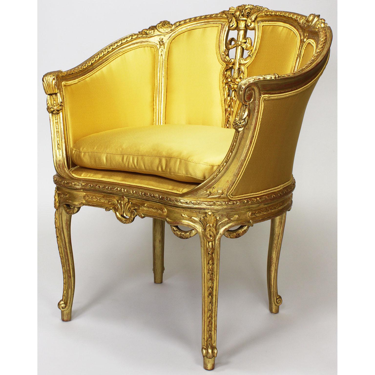 Raffinata coppia di poltrone Bergère intagliate in legno dorato in stile Belle Époque francese del XIX-XX secolo. Le cornici finemente intagliate sono centrate da una fiaccola floreale legata con un nastro, affiancata da intagli floreali, fianchi,