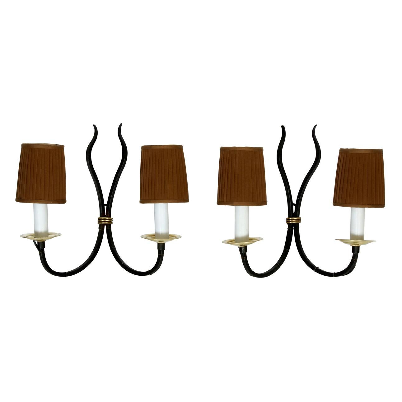 A pair of French black iron and brass two arm Art Deco style sconces, sold without shades.