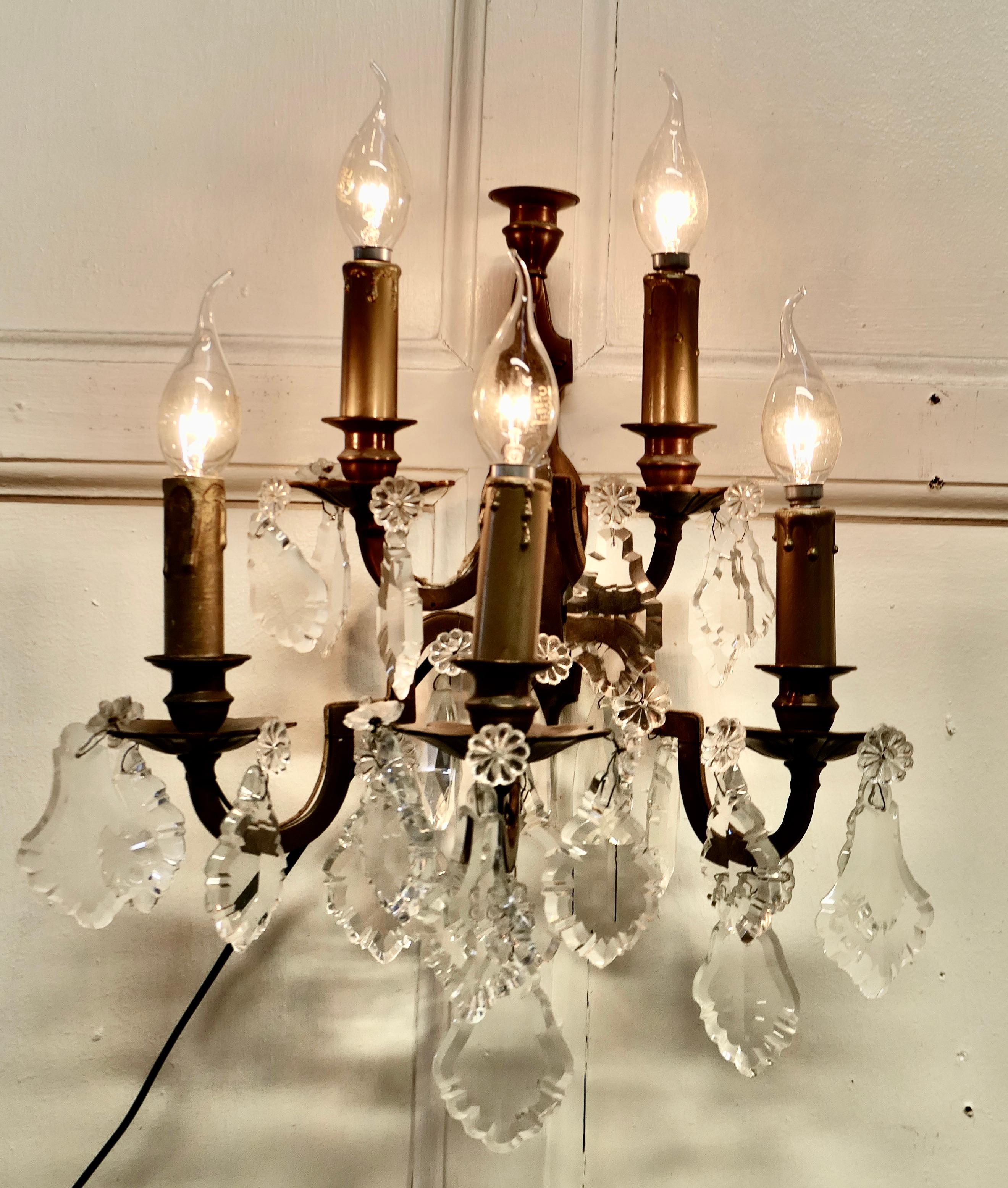 A pair of French Brass 5 Branch wall light, chandeliers 


A very handsome pair of Large Heavy Brass wall lights, the lights are in the classical style set with large crystal drops, the brass is a dark colour and there is an additional sconce at