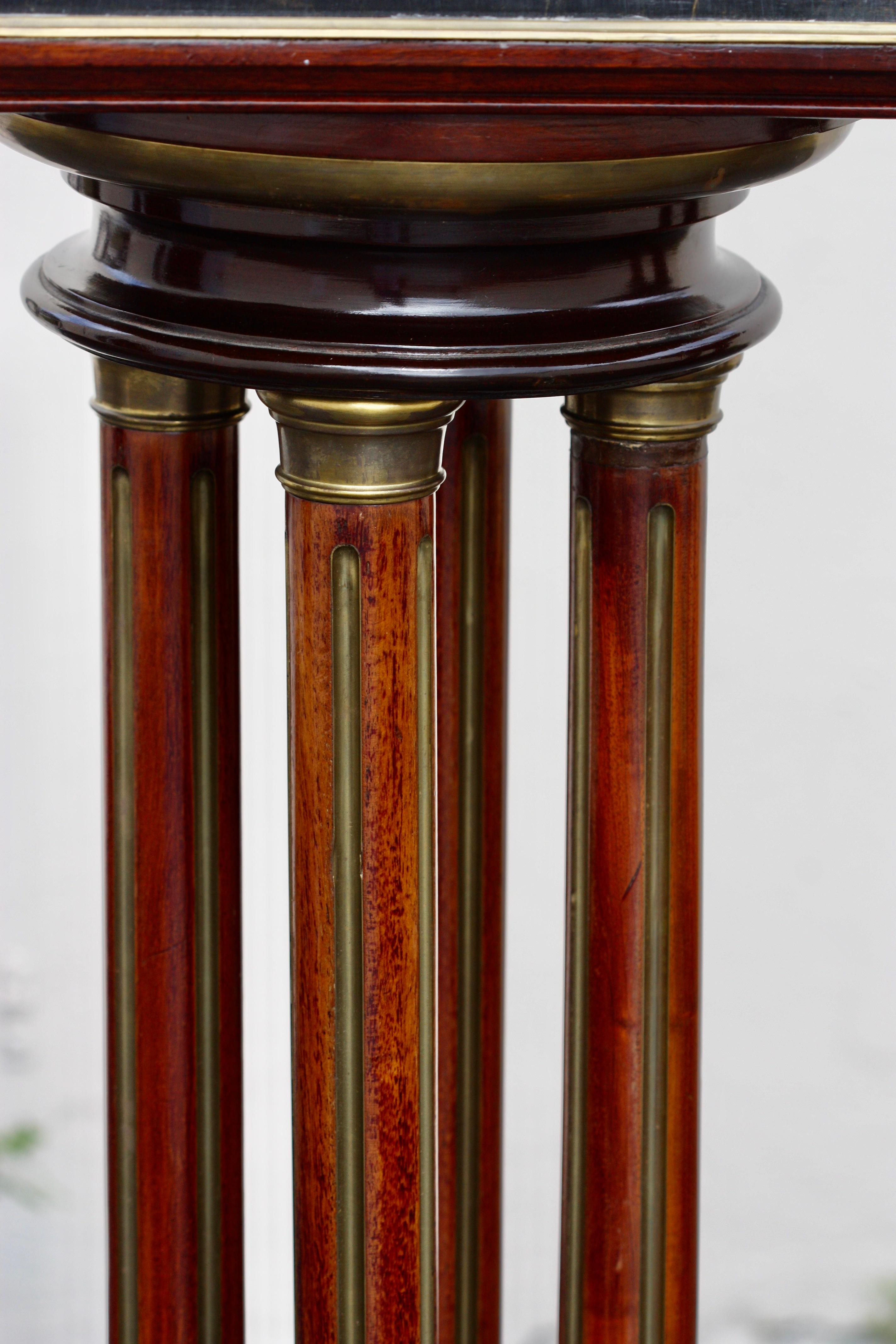 A pair of French brass mounted rosewood pedestals 
Late 19th-early 20th century
Each with revolving square black marble top supported by four fluted columns, 
on a square base 
Measures: Height 44.5 in. (113.03 cm.) 
The tops 12.75 in. (32.38