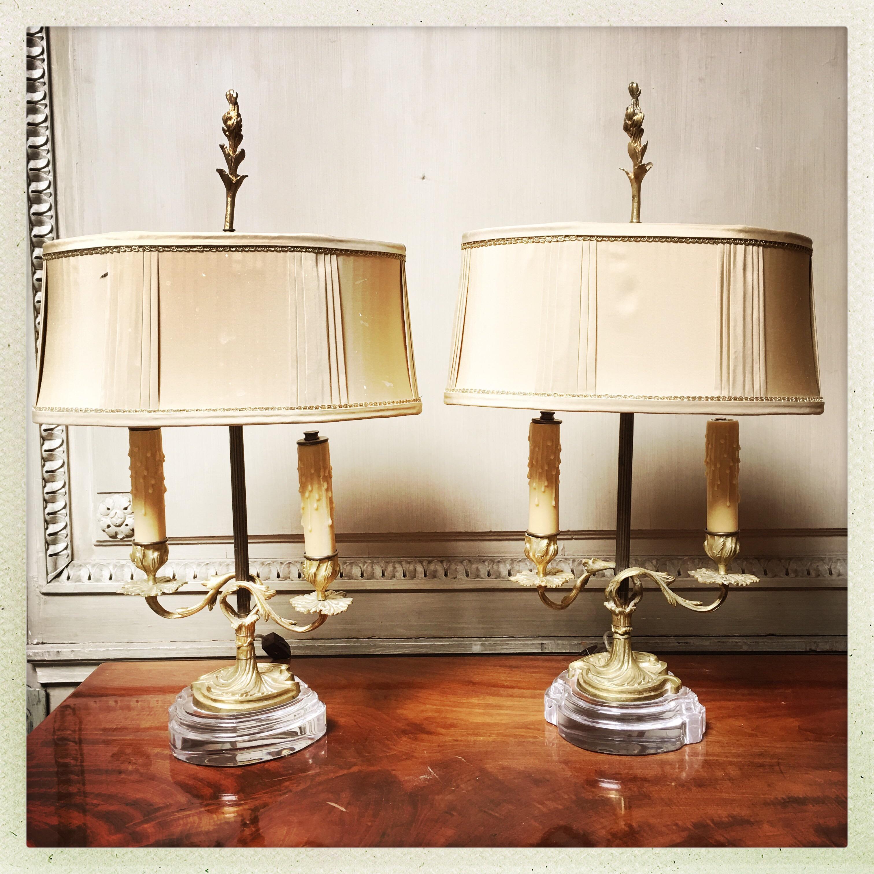 Coppia di candelieri francesi in bronzo montati come lampade su basi in acrilico.