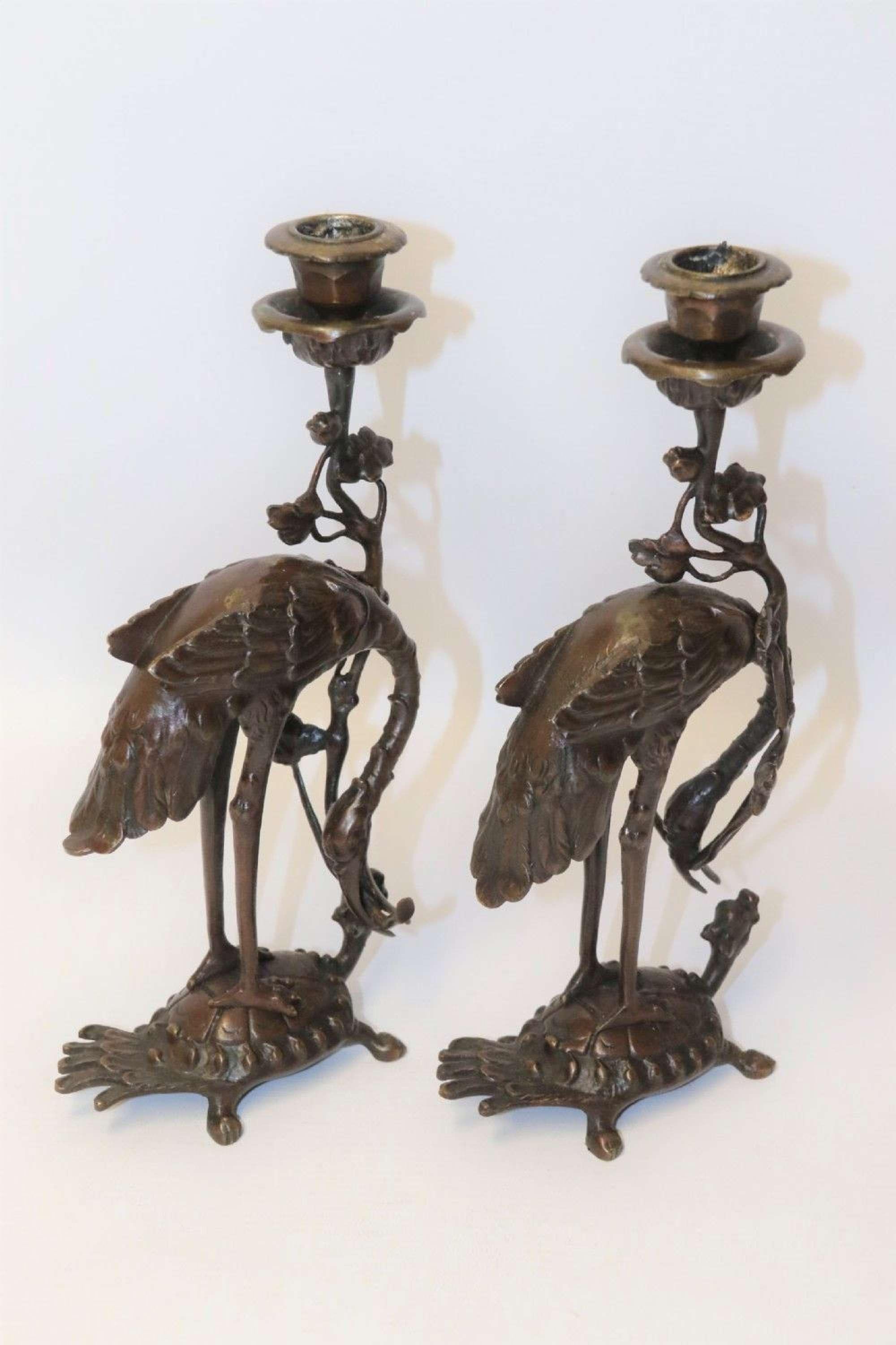 A pair of French bronze candlesticks in the form of Storks

This decorative pair of French bronze candlesticks are in the Japanese style and are modelled in the form of storks standing on the backs of tortoises while holding a leafy branch which