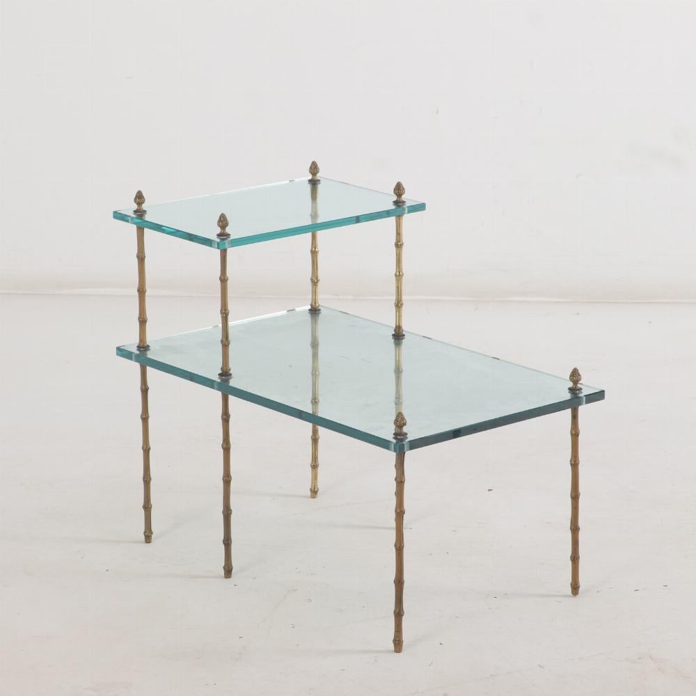 Cette paire de tables d'appoint est composée de deux niveaux d'étagères en verre soutenues par des cadres en bambou de couleur bronze. 

Cette paire apportera un accent aérien à un canapé ou à des chaises longues.

Démontable pour la livraison.