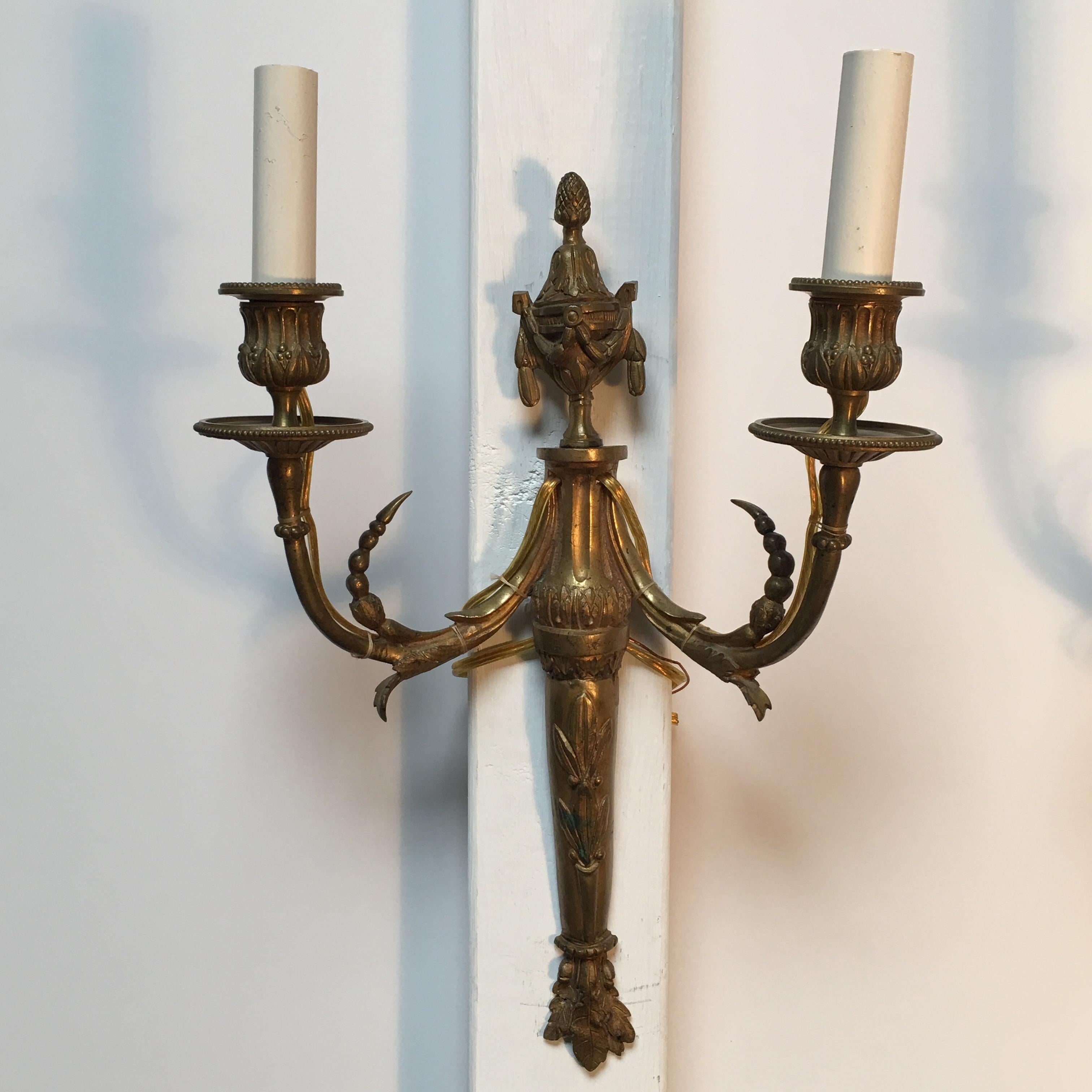 A pair of French Louis XVI style bronze wall sconces.