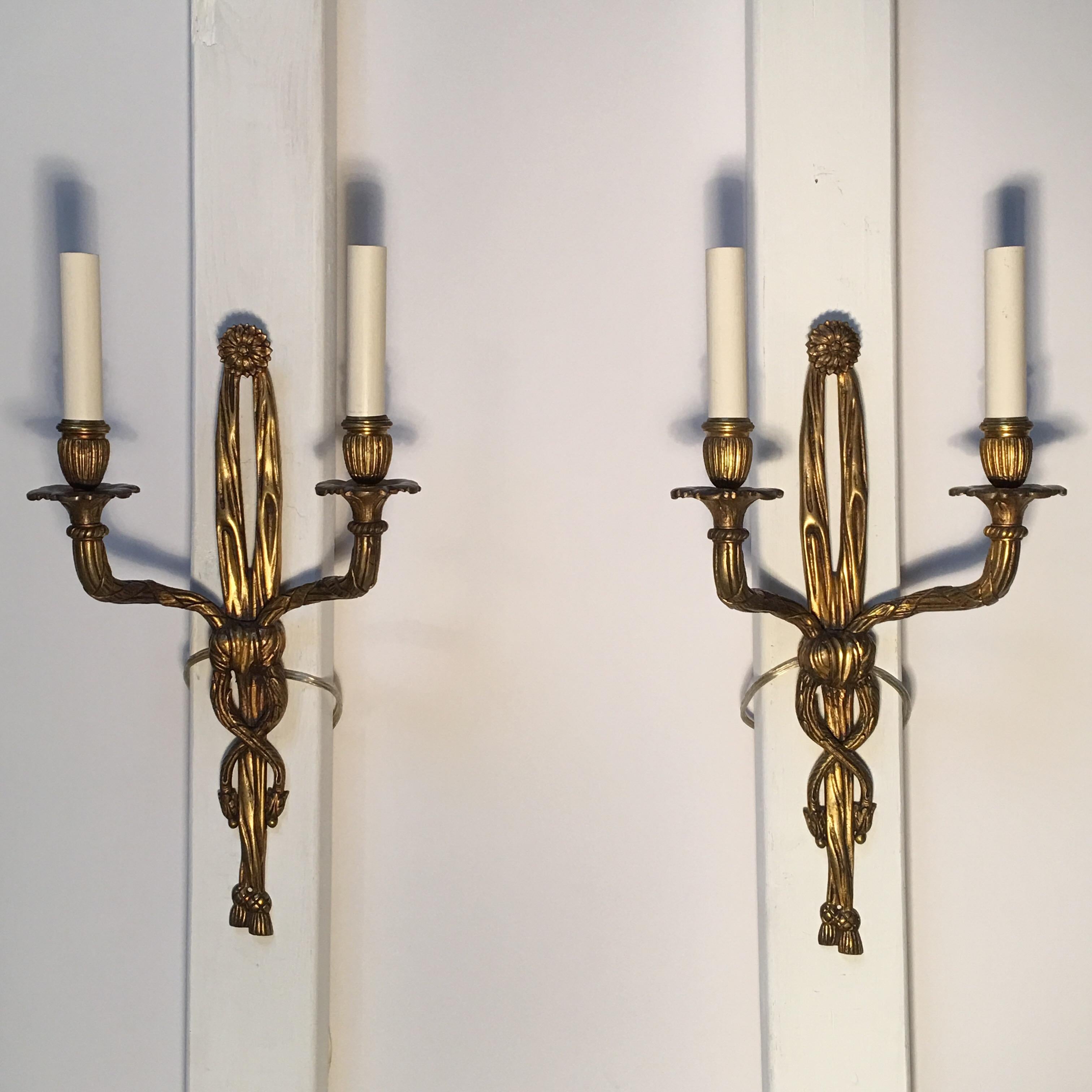 A pair of two-arm French bronze Louis XVI style wall sconces.