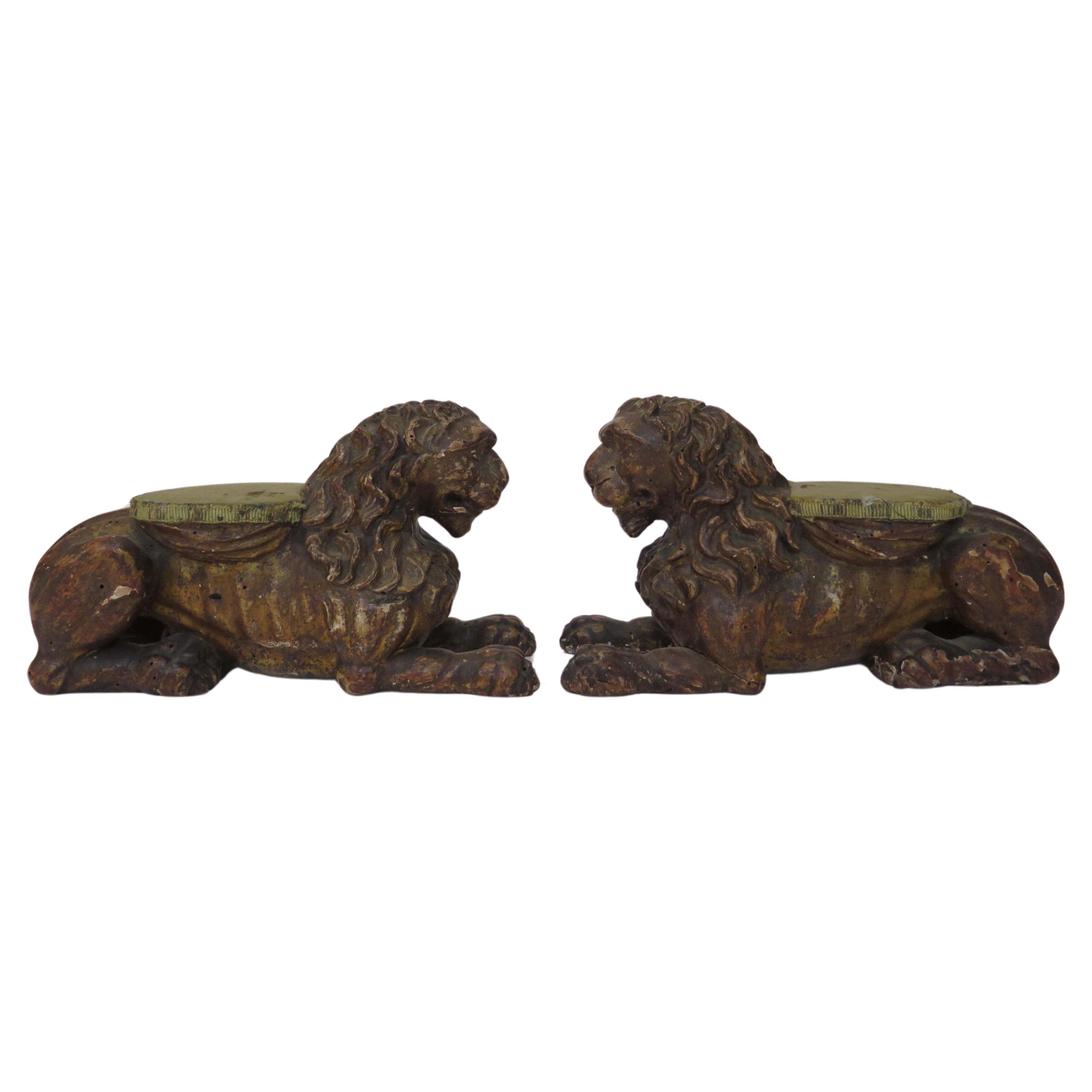 Coppia di sculture di leoni reclinati in legno dorato intagliato francese, fiorentino, con cuscinetto