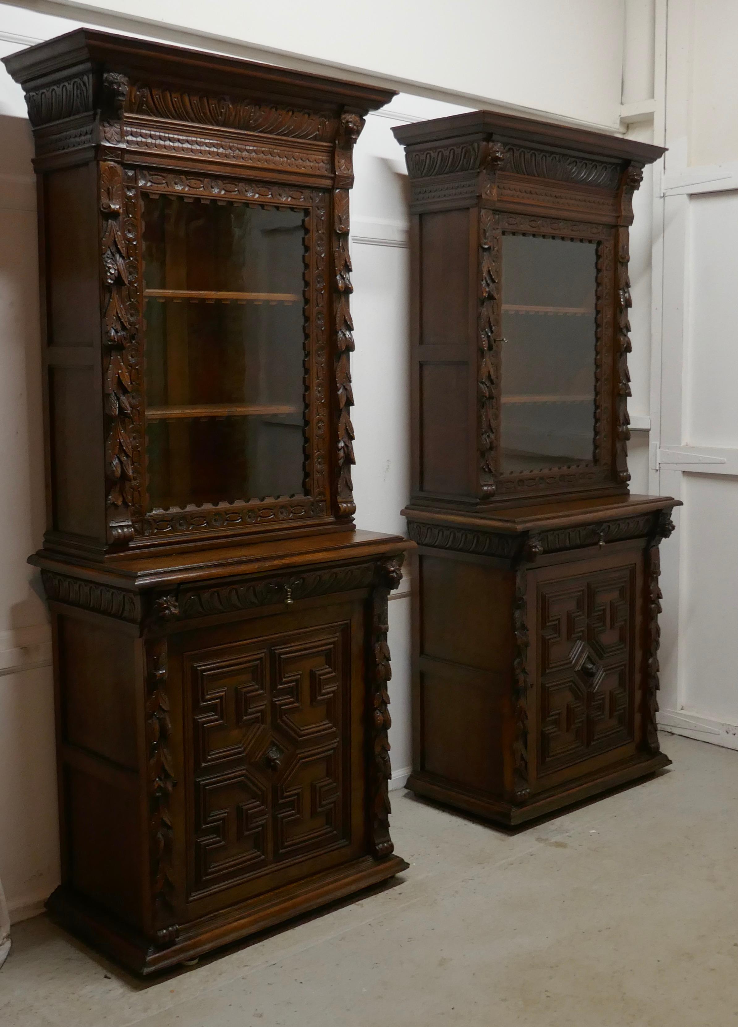 A pair of French carved Gothic oak bookcases

The upper section of the Bookcases have a glazed door enclosing 2 adjustable book shelves, these have an attractive carved front edge. 
The Tops have a large carved cornice and there is carving on the