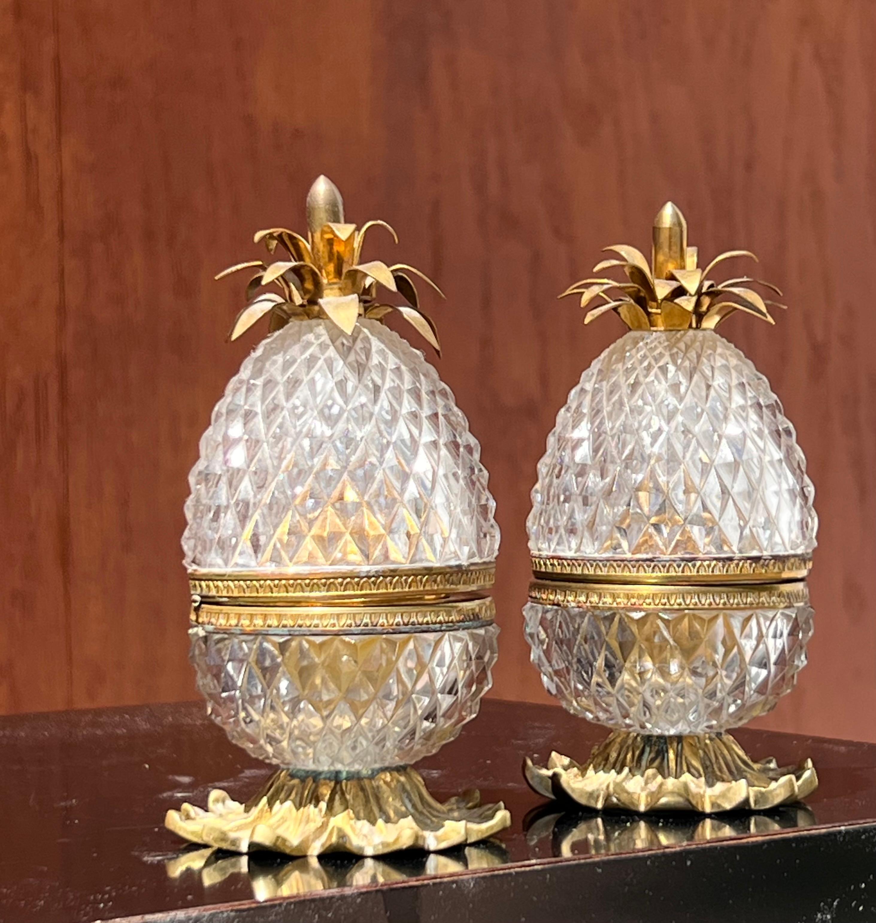 A handsome pair of French diamond-cut crystal and gilt brass « pineapple » table lighters by Baccarat, circa 1940. Both are hinged at the center and showcase a decorative gilt brass crown and leaf base relief.