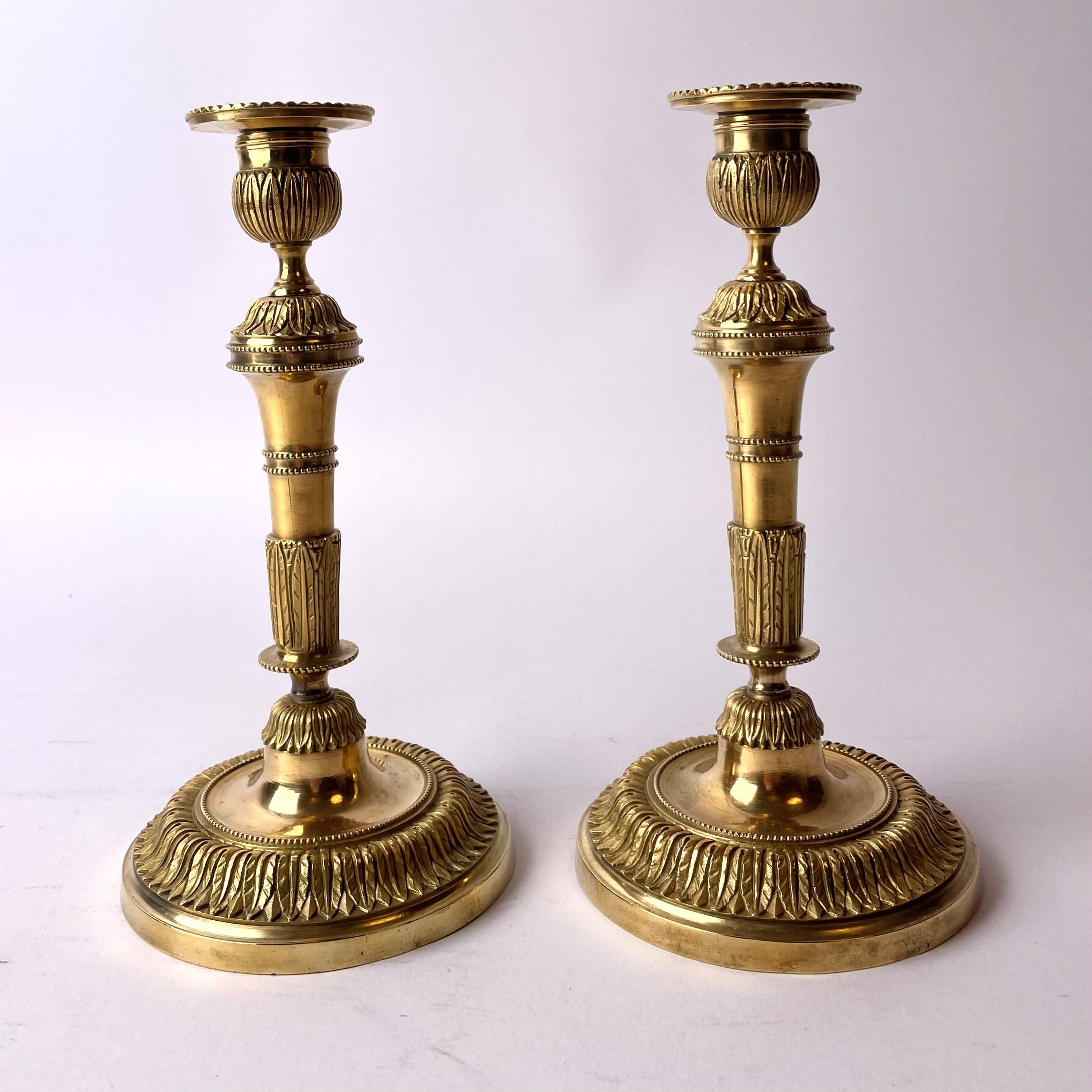 Ein Paar seltene und schöne französische Directoire-Leuchter aus vergoldeter Bronze aus dem späten 18. Jahrhundert.

In sehr gutem antiken Zustand.

Im unteren Teil des Fußes mit 