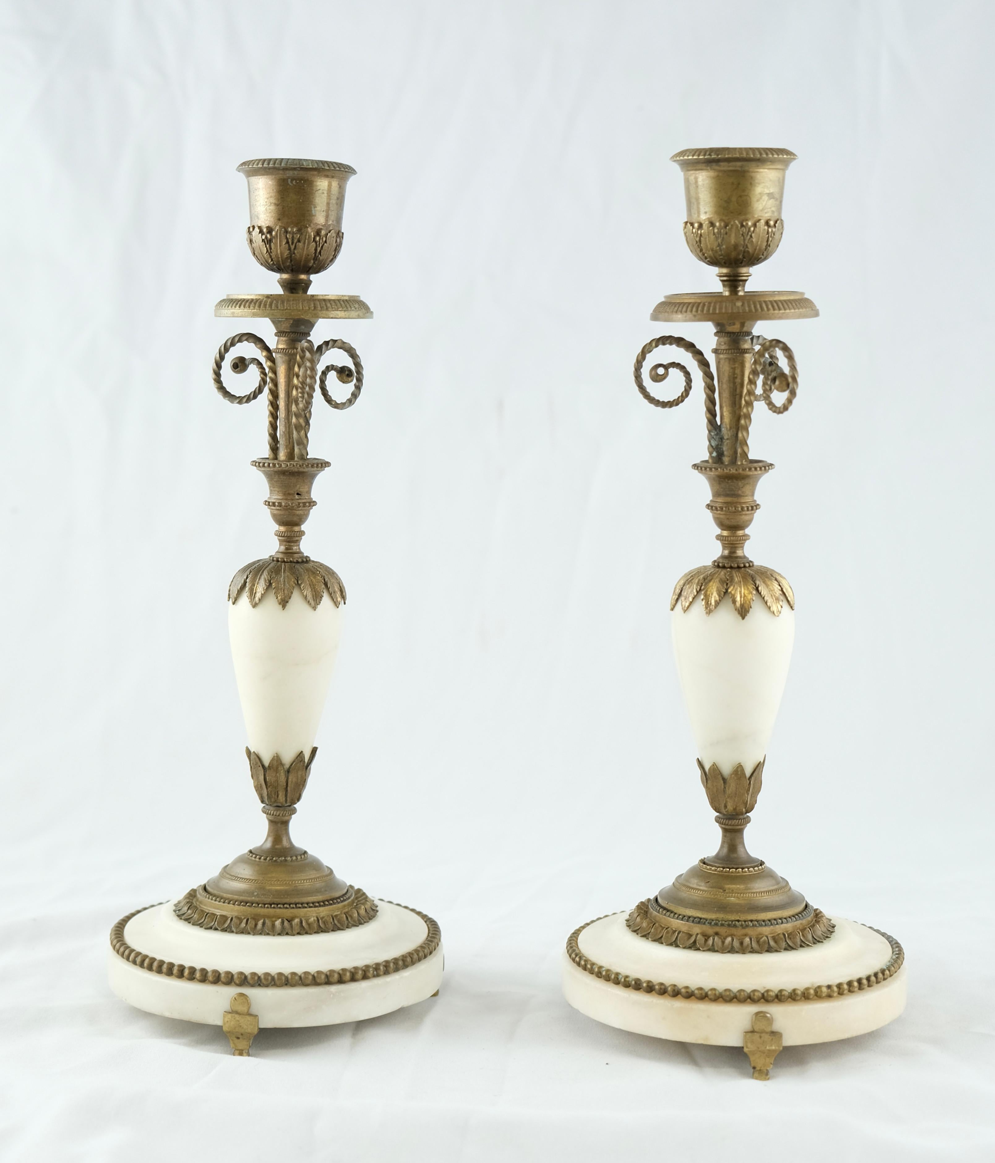 A pair of French candlesticks in a wonderful condition. White marble mounted with bronze ornaments. The quality of the castings and chiseling is high. the design is romantic and beautiful.