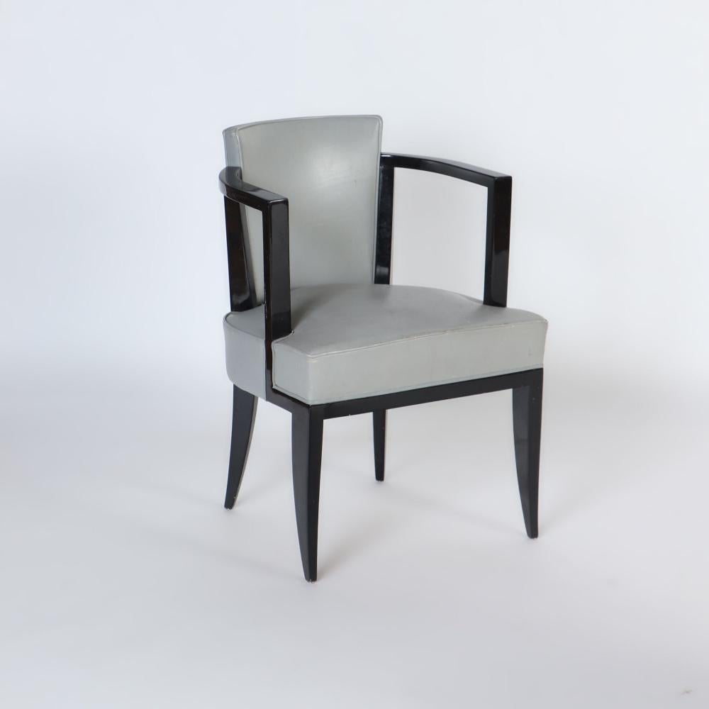A very stylish pair of French ebonized open armchairs with faux leather upholstery. Circa 1940