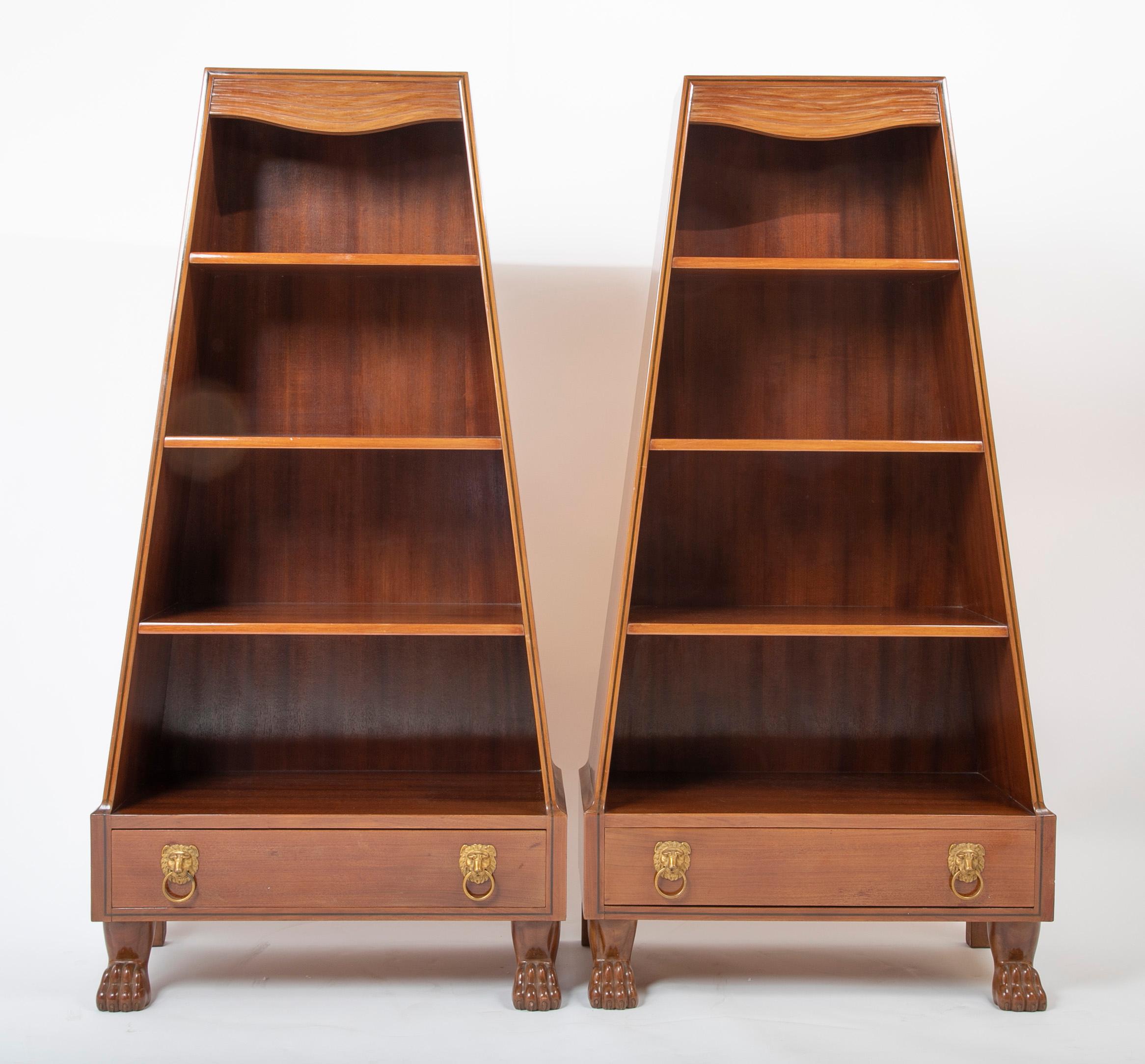 A pair of mahogany pyramid form bookcases raised on paw feet with a single drawer with doré bronze lion form pulls. Sold a pair, circa 20th century.