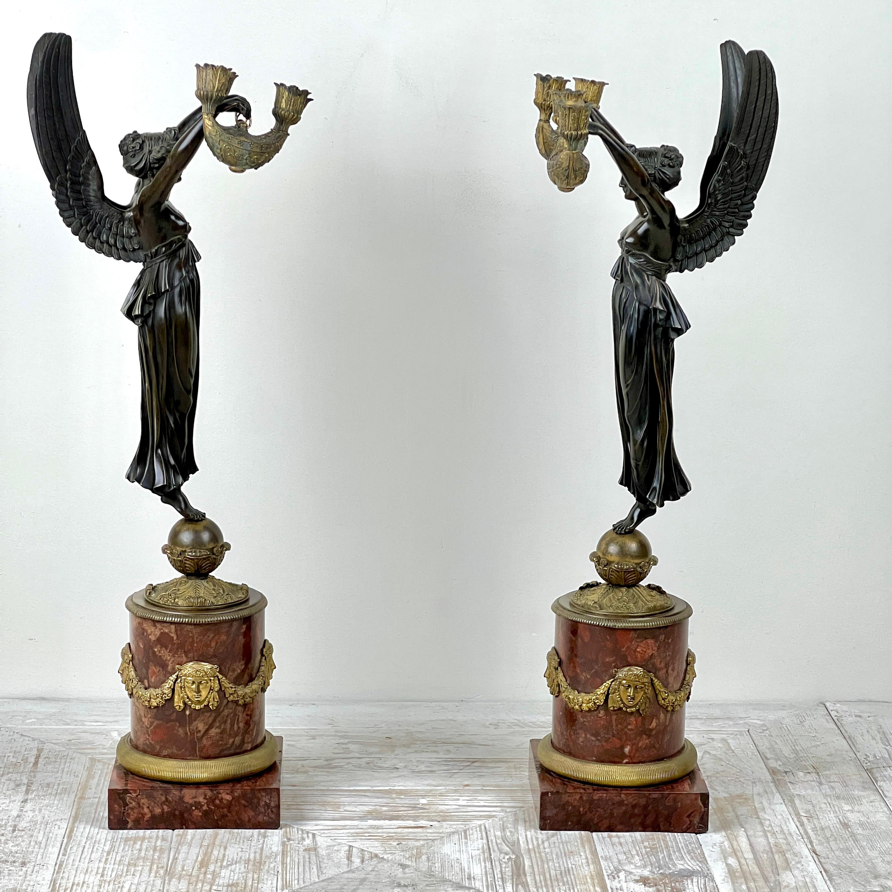 Gran pareja de candelabros imperio de bronce patinado y mármol

Cada candelabro presenta una figura clásica de Victoria alada que sostiene un estilizado candelabro de lámpara de aceite con boquillas estriadas. La figura alada lleva un vestido