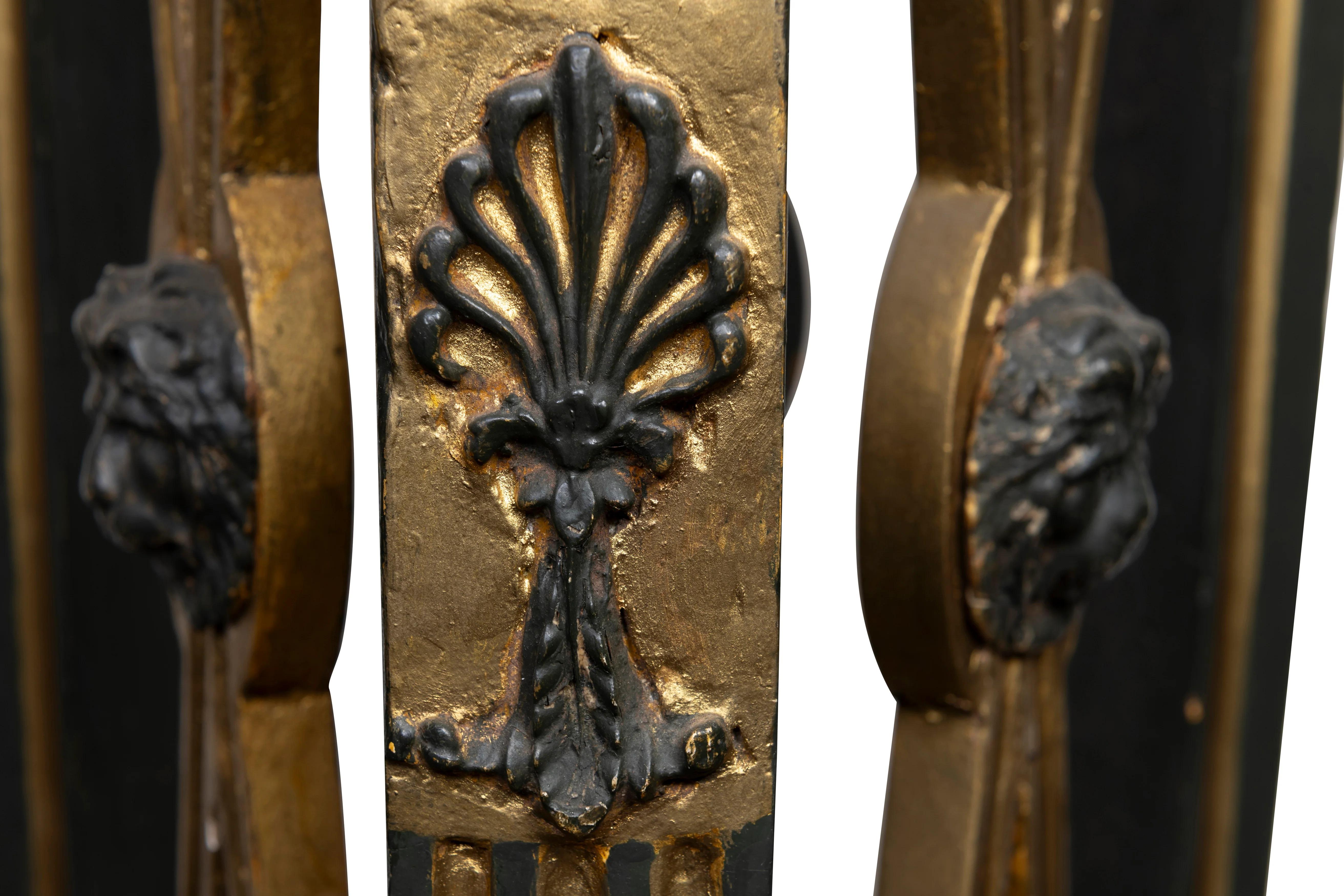 A Pair of French Empire Polychrome Gilt-Wood Torchères, 19th Century

Description:
Each torchère with a circular stone top above a concave triform capital with a rosette to each face, the three reeded supports each with an Egyptian mask head above a