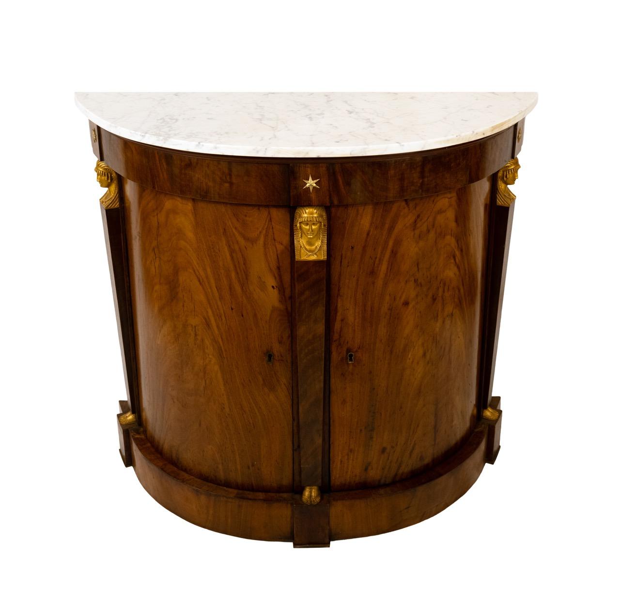 Una coppia di armadi demilune in stile Impero francese. I piani in marmo bianco sono sostenuti da basi in palissandro con due ante. Le basi sono decorate con teste di figure classiche e stelle dorate. Circa 1880