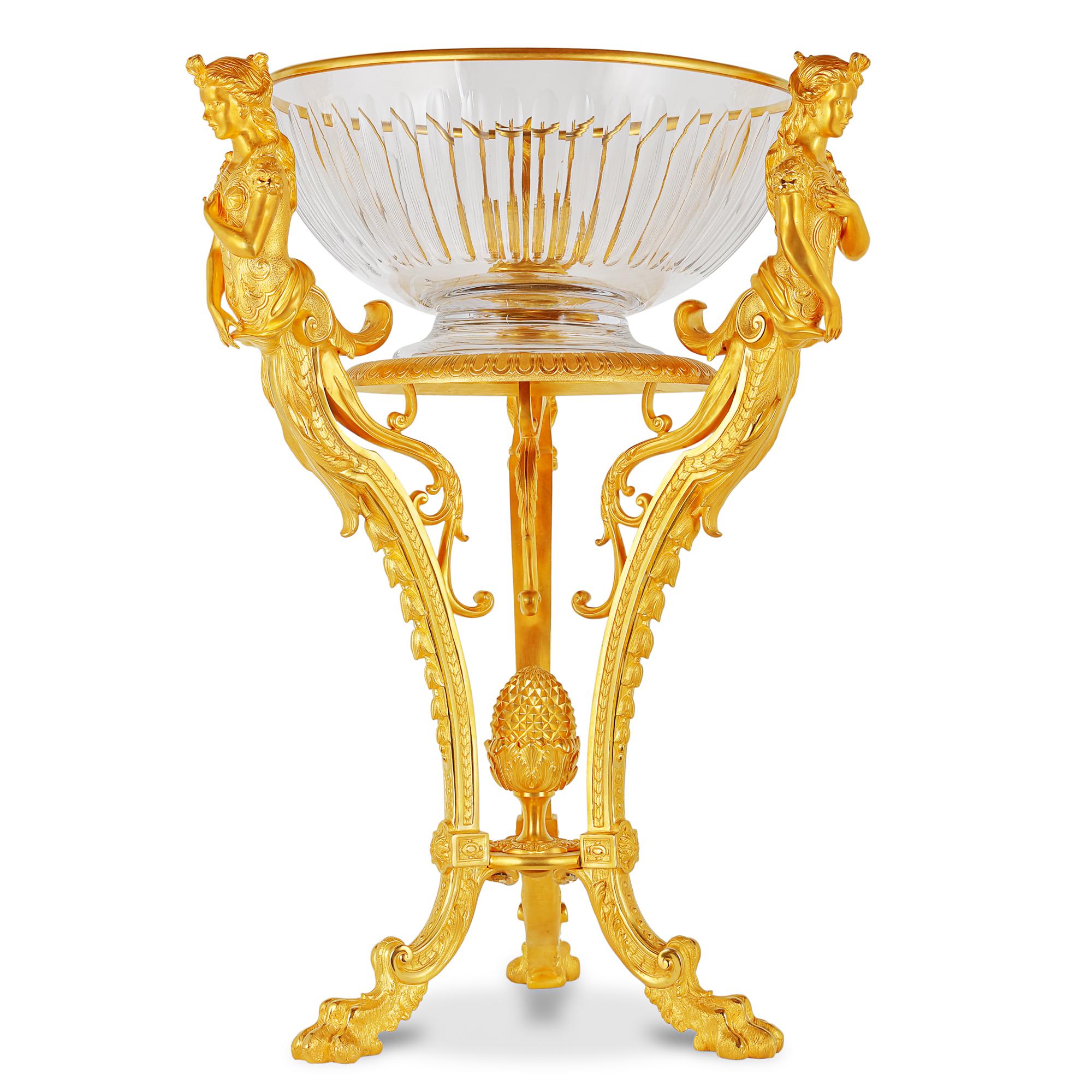 These classic pair of French Neoclassical style jardinieres are wrought from ormolu & glass. The pedestal bowl is mounted on a rounded stand which is held together at three point with ormolu maidens which extends downwards to a floral paw like base.