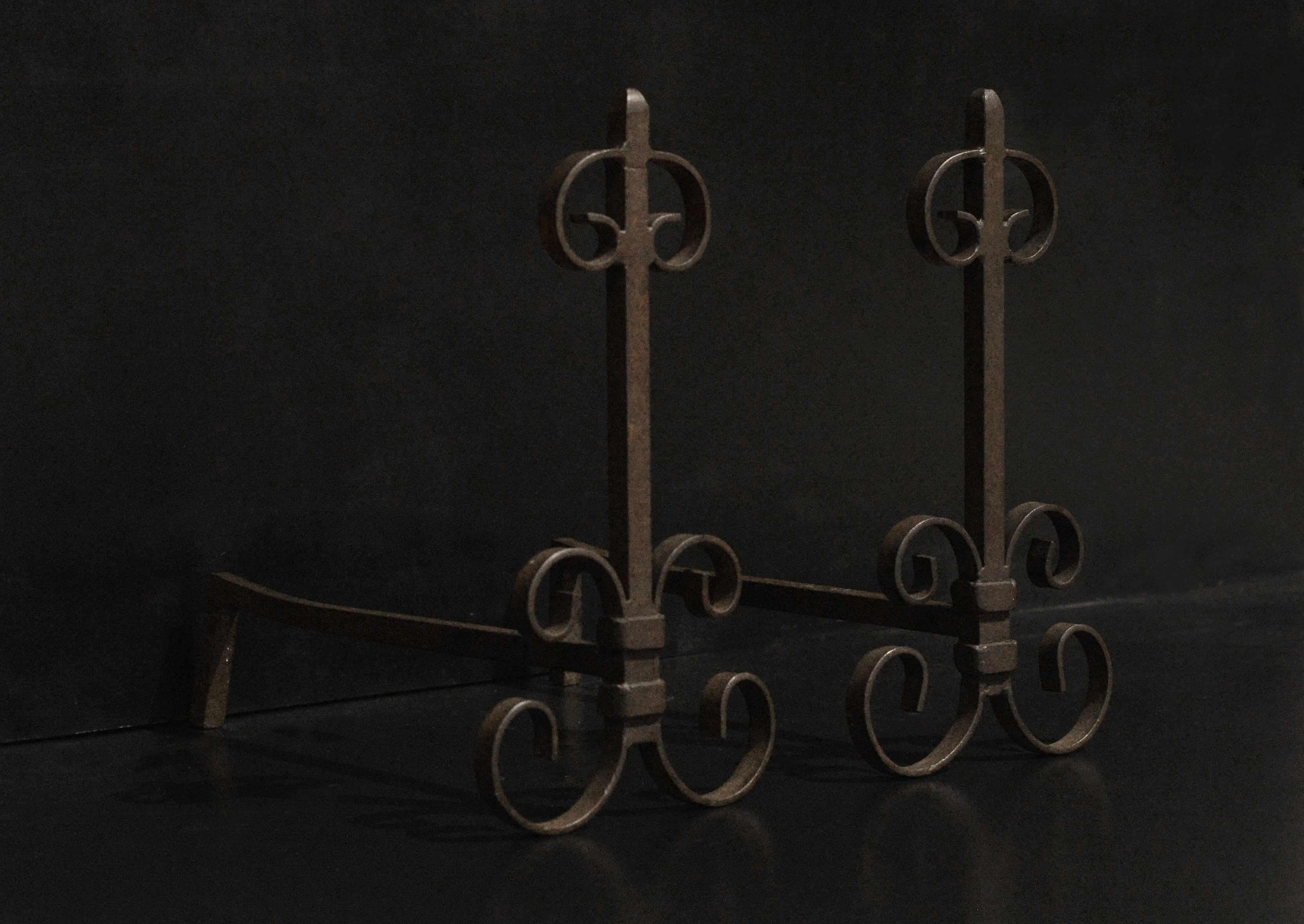A pair of French wrought iron firedogs with scrolled detailing, French, circa 1900. With a waxed finished, could be polished if required.

Measurements:
Height: 470 mm 18 1/2 in
Width: 250 mm 9 7/8 in
Depth: 510 mm 20 1/8 in.
 