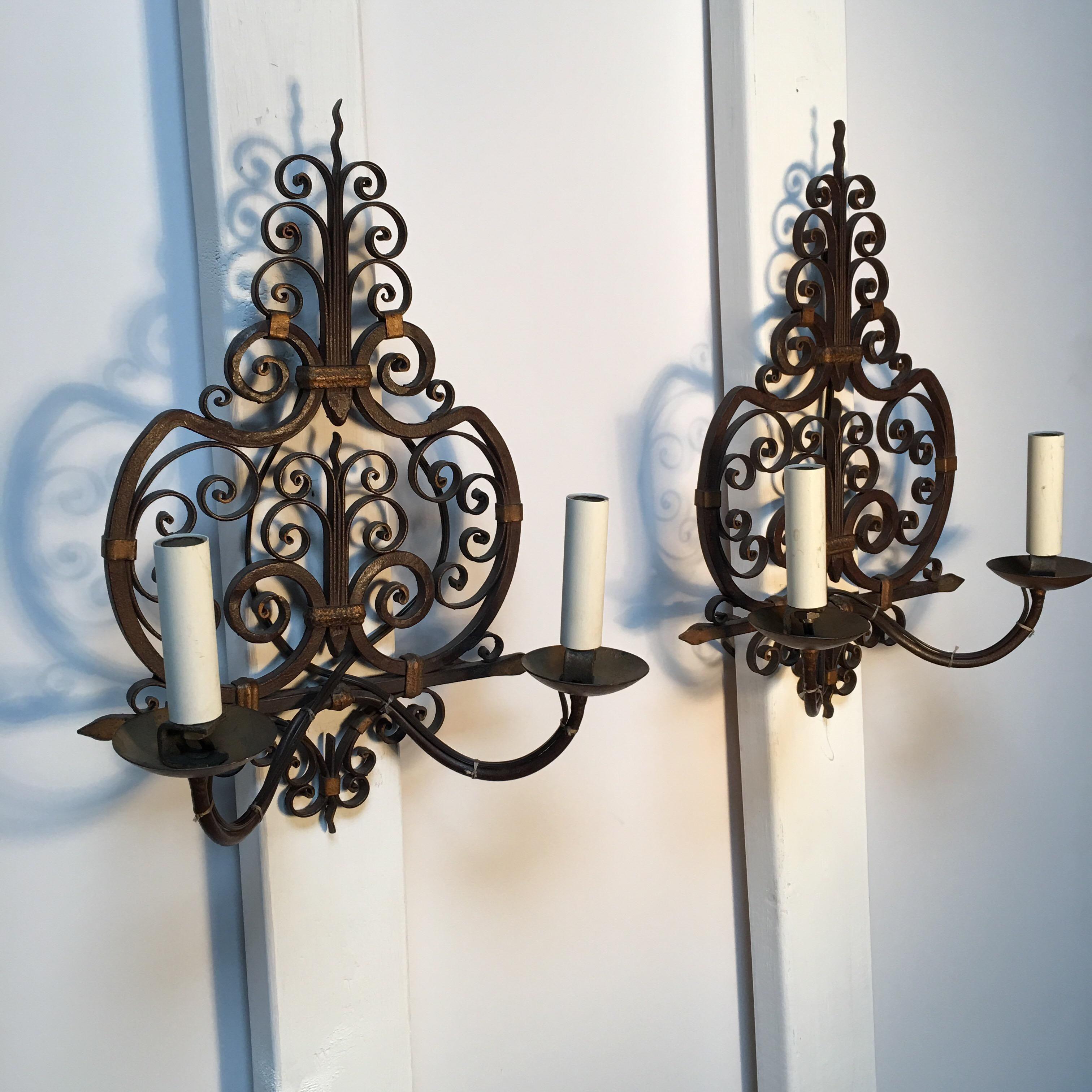 A pair of French forged iron wall sconces.