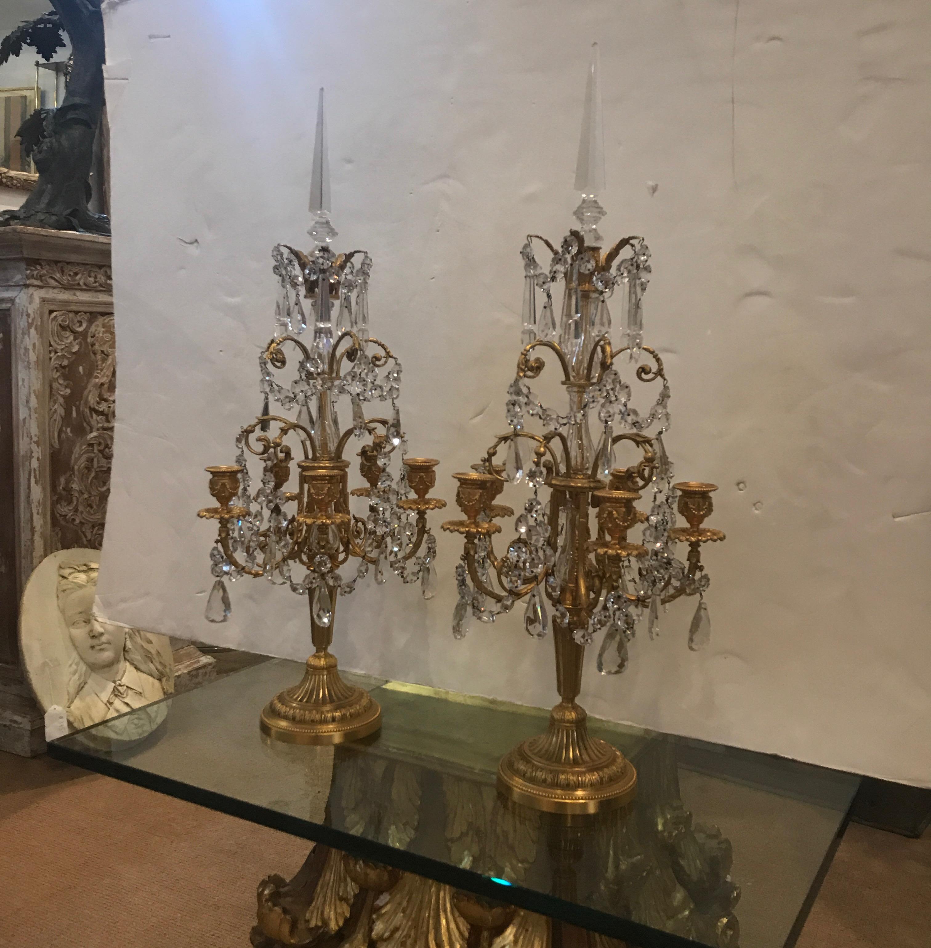 Ein elegantes Paar vergoldeter Bronze- und Kristallkerzen mit fünf Lichtern im Stil Louis XV. Die obere Turmspitze hat einen facettierten Abschluss mit einem wunderschön gegossenen Korpus aus Doré-Bronze mit drapierten Kristallen über und über. Der