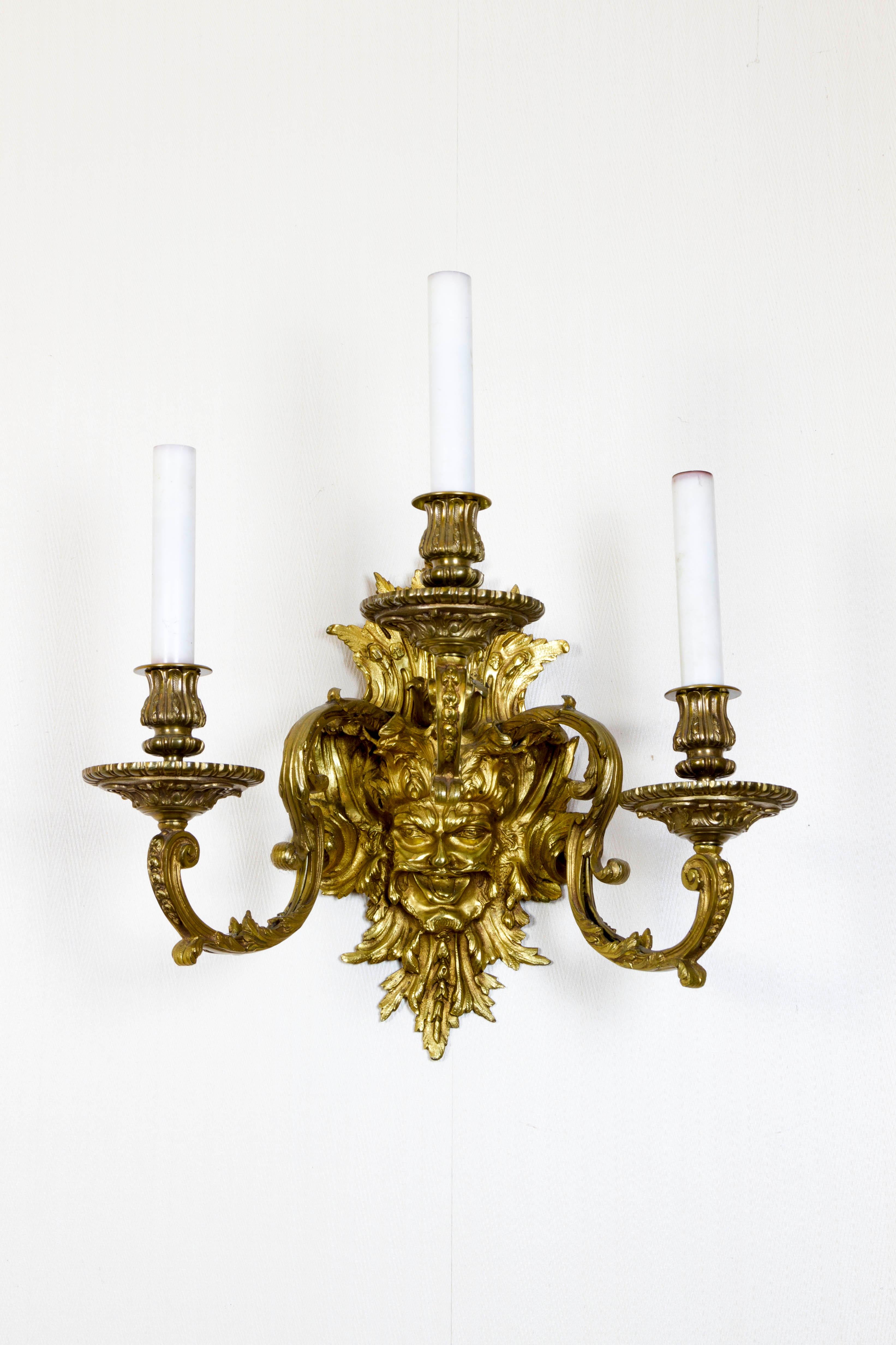 A pair of French gilt bronze wall sconces with Mascarons after a design by André Charles Boulle

Fine 19th-century cast, electrified.

(Dimenions given without candle tubes)