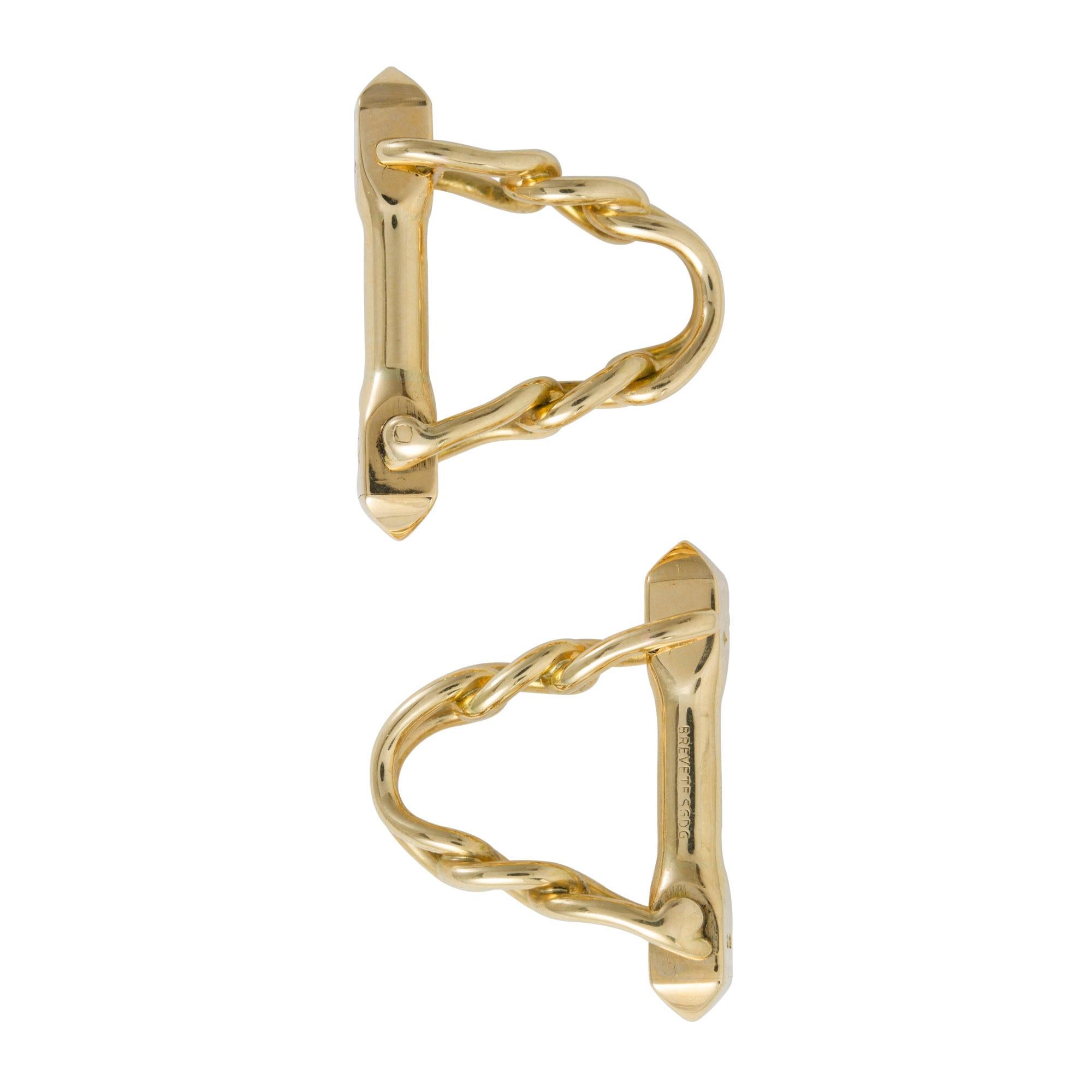 A pair of French gold cufflinks, the yellow gold chain link designed stirrup cufflinks, each with a hinged bar, bearing French gold hallmarks for 18ct gold, circa 1950, measuring approximately 2.1 x 1.5cm, gross weight 12.0 grams.

Should you choose