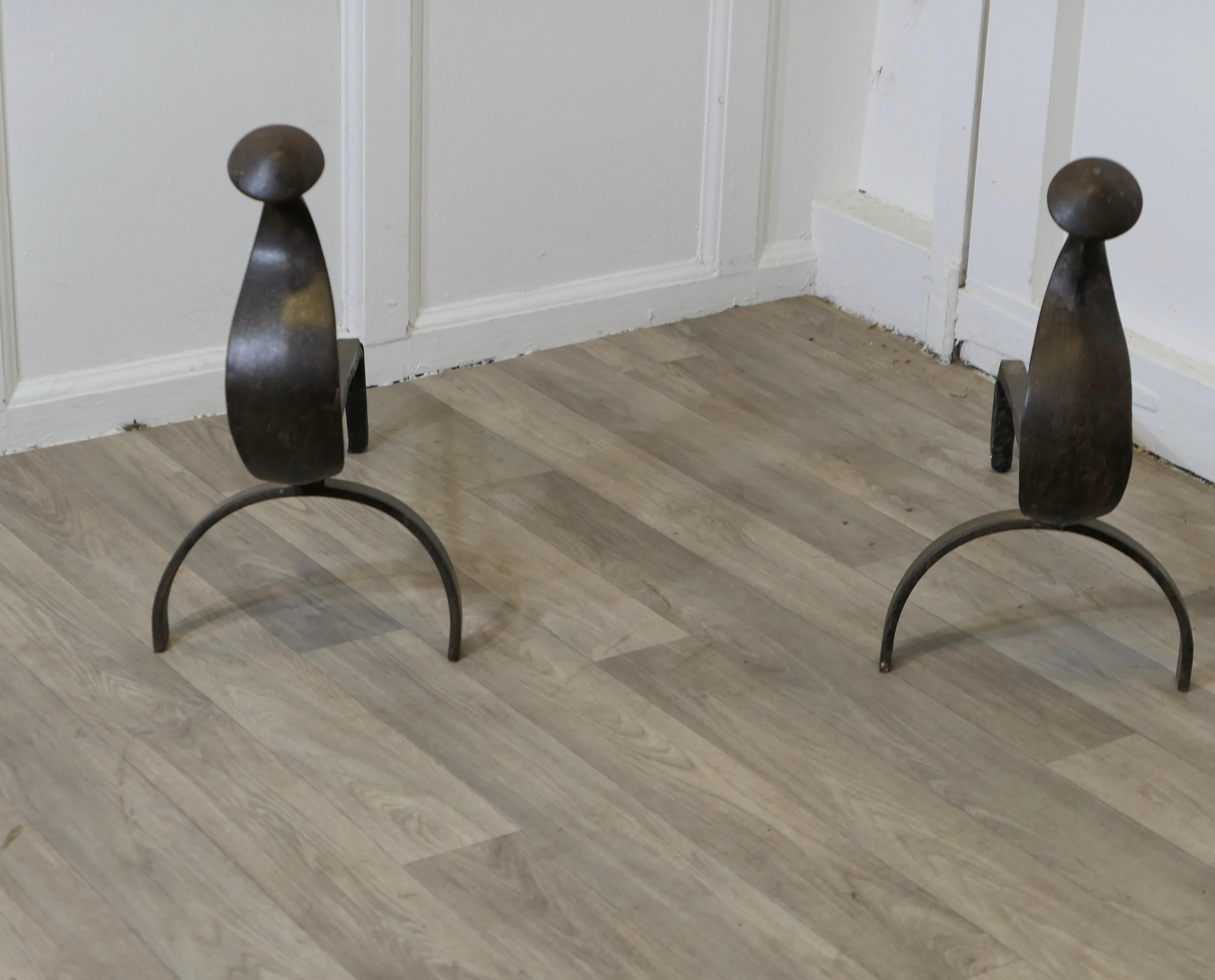 Paire d'andirons ou chiens de feu en fer de style gothique français

Il s'agit d'une lourde paire de chenets anciens, fabriqués en fer et reposant sur un large pied avant d'aspect gothique.
Les andirons ont une hauteur de 18
