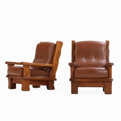 A Pair of French Heavy Oak Brutalist style Open Arm Chairs, C. 1960.