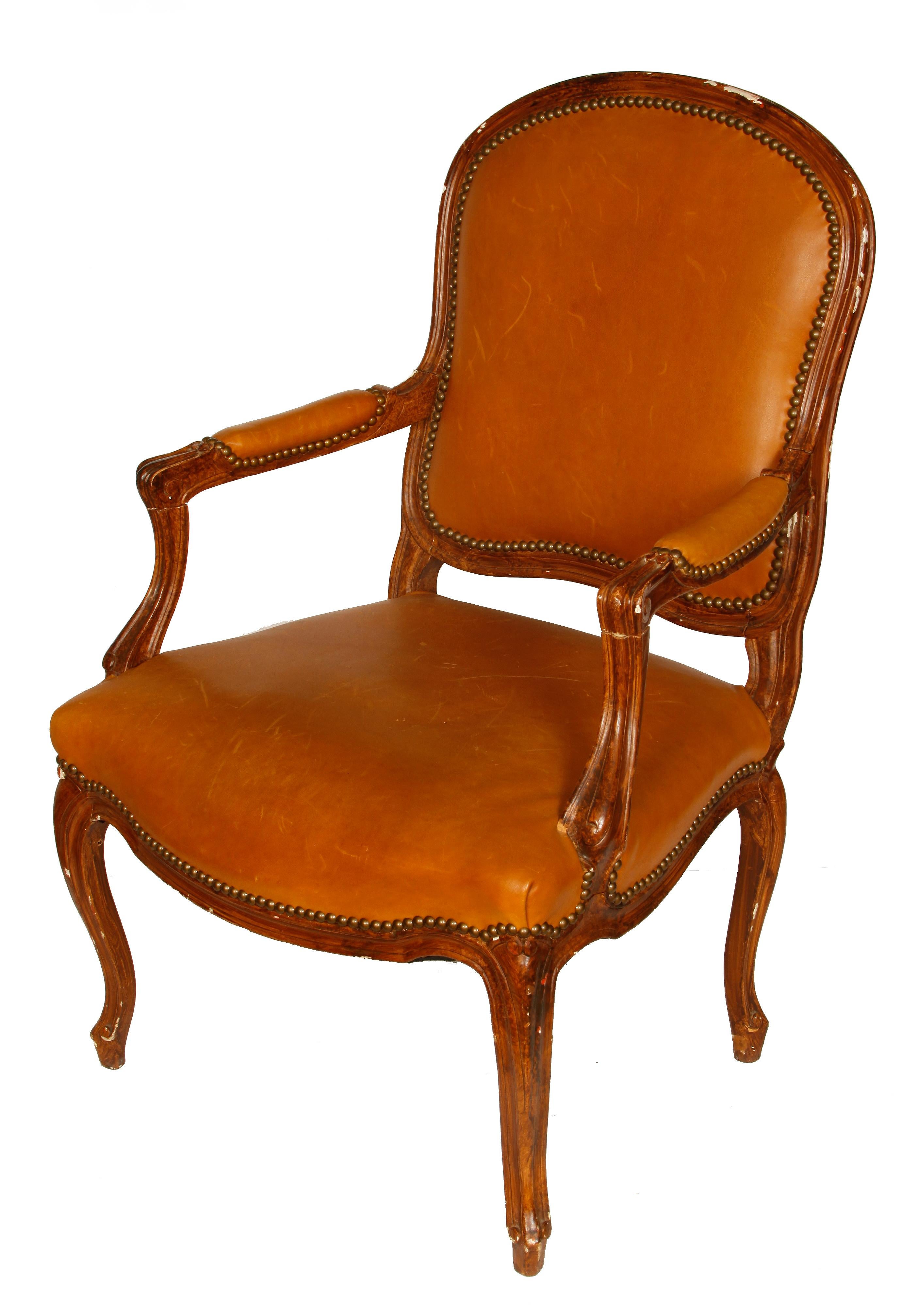 Paire de fauteuils bergères en cuir de style Louis XV, avec garniture en tête de clou sur le cuir, pieds cabriole sculptés et dossiers en tissu à carreaux bleu ardoise et ivoire.  Quelques rayures sur le cuir