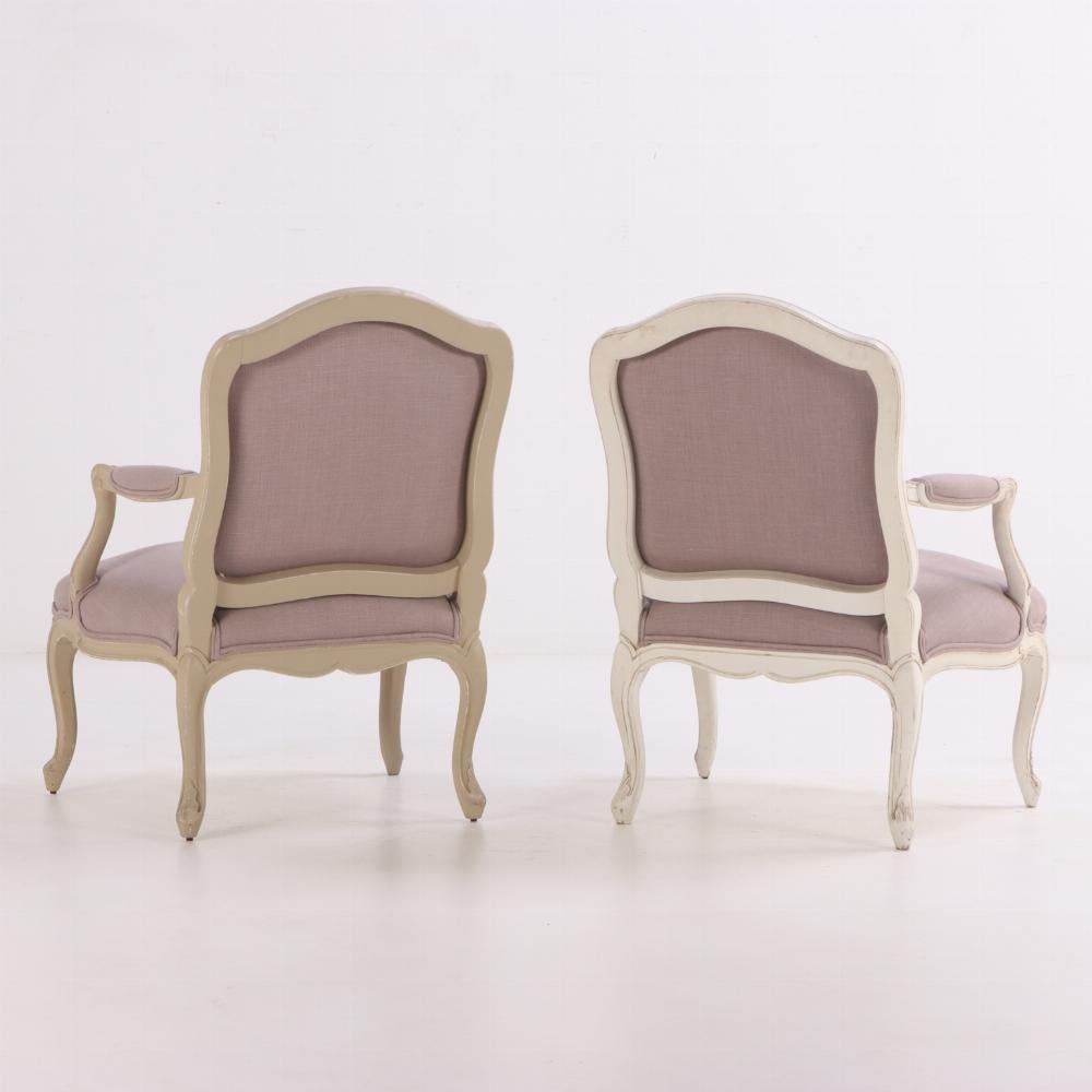 Charmante paire de fauteuils ouverts français. Chaque fauteuil présente un cadre en bois sculpté et peint avec des pieds en cabriole, des accoudoirs en volute et un dossier en forme. Récemment retapissées dans un nouveau tissu, ces chaises allient