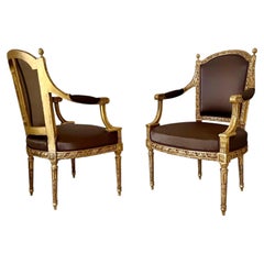 A pair of French Louis XVI Carved Giltwood fauteuils, late 18th century Stamped