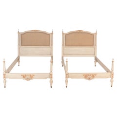 A pair of French Louis XVI painted twin beds with partial gilt, c 1940.