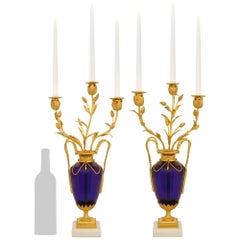 A pair of French Louis XVI st. Glass Ormolu and white Carrara marble candelabras