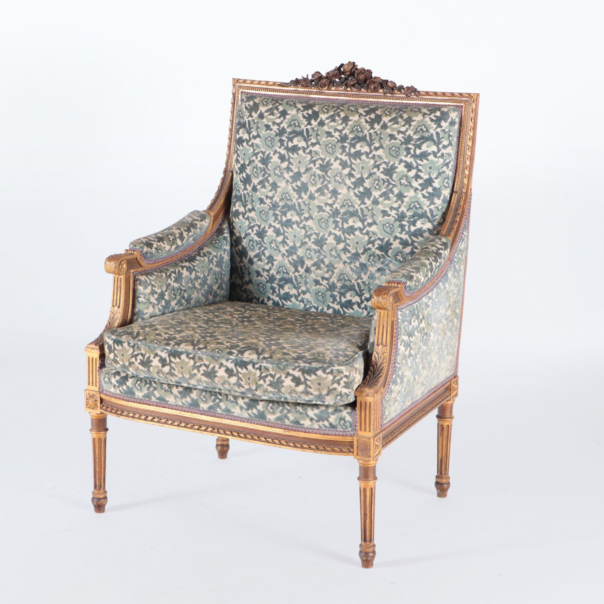 A pair of French Louis XVI style giltwood bergere chairs with carved crests on four square tapering legs. C 1900.