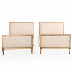 A Pair of French Louis XVI style Painted and Gilt Twin Beds, C. 1940.