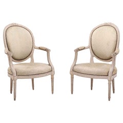 A pair of French Louis XVI style relief carved open armchairs circa 1860.