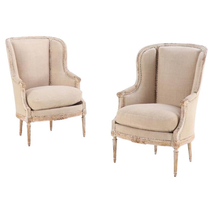 A Pair of French Louis XVI style upholstered and painted bergere chairs, C 1900.