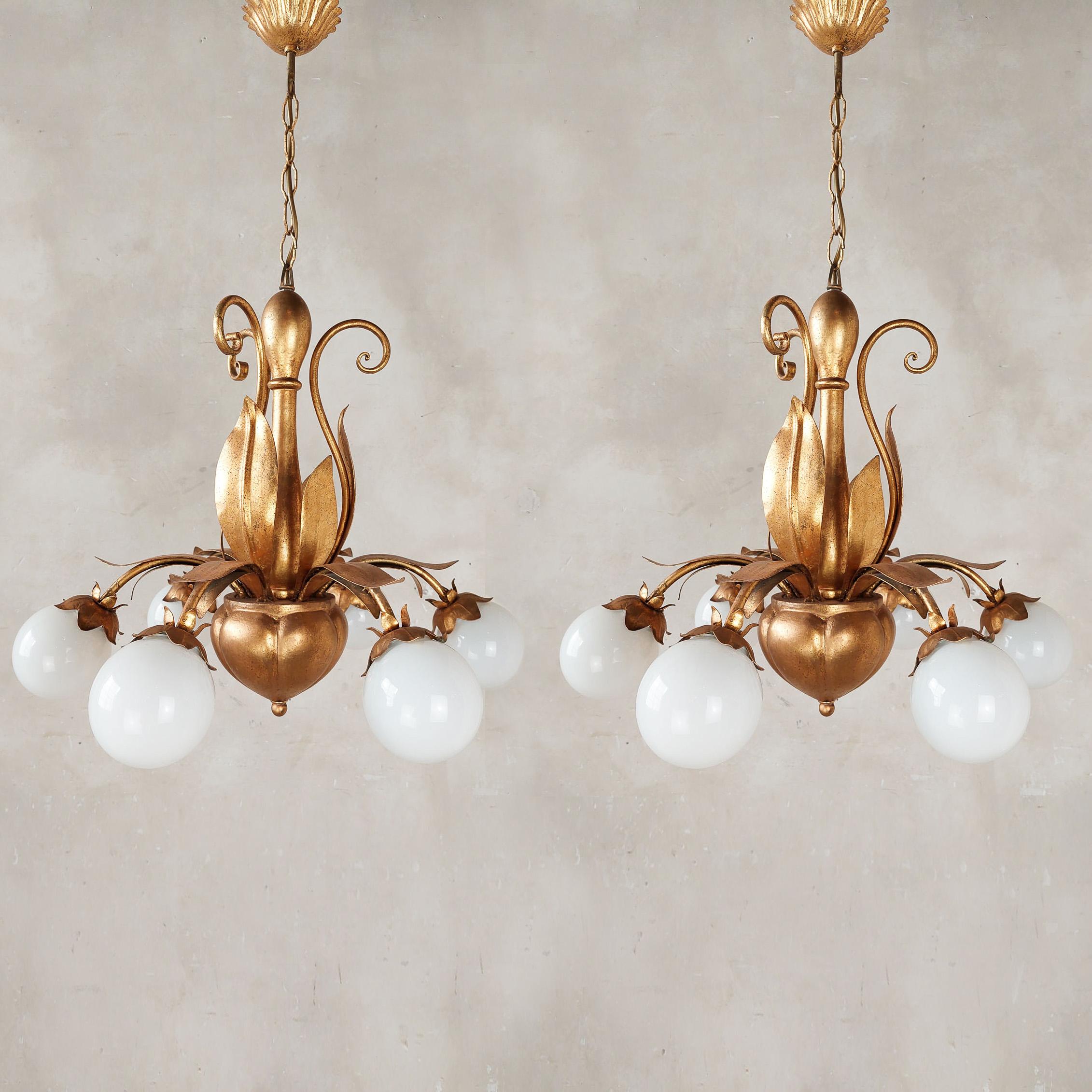 A pair of French, mid-century gold (gold patinated) Hollywood Regency lamps with leaves. The 6 light points of these chandeliers are covered with opaline glass spheres / bulb caps.

height 79 cm, diameter 55 cm

price for the pair
