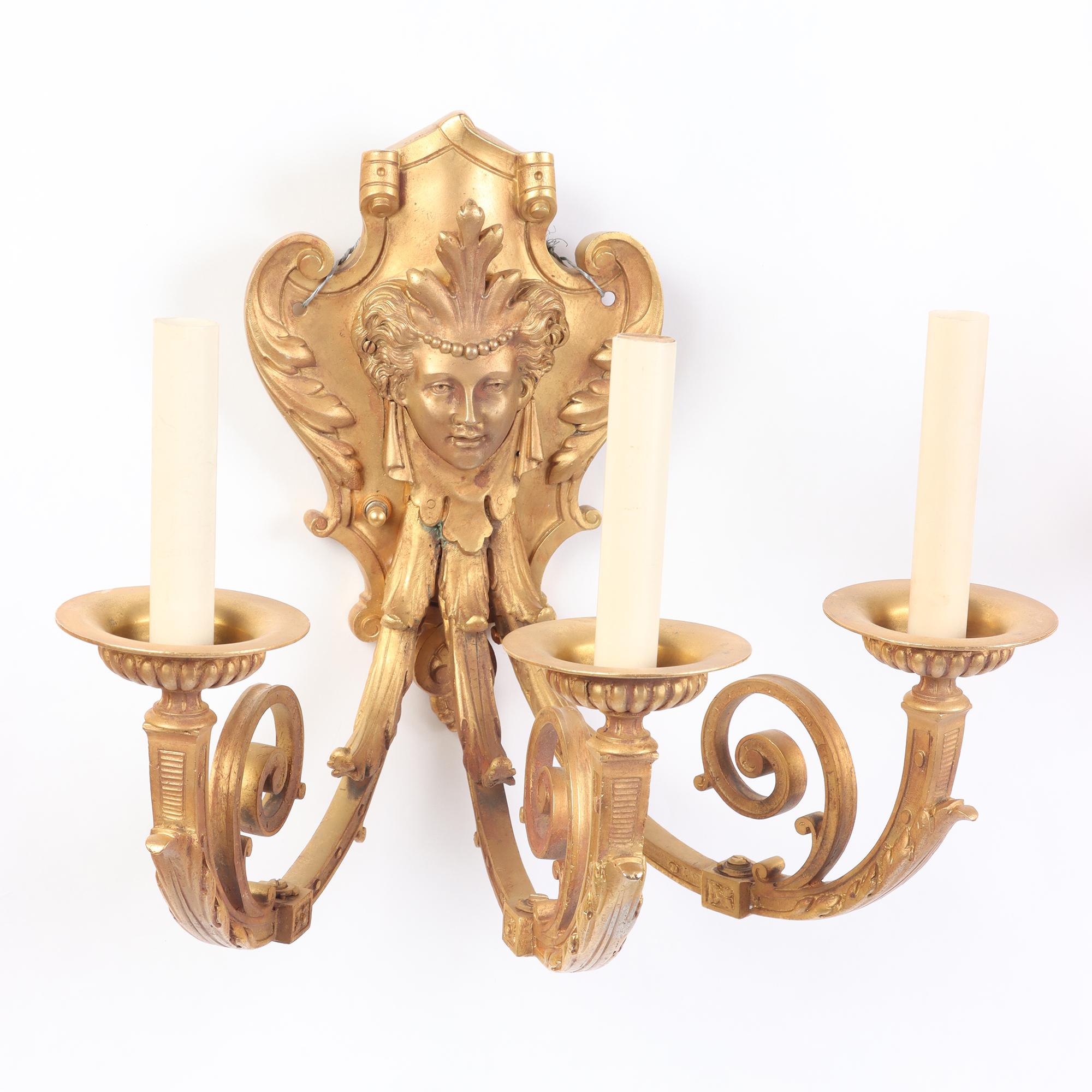 Coppia di appliques in bronzo dorato in stile neoclassico francese con maschere classiche. XIX secolo.