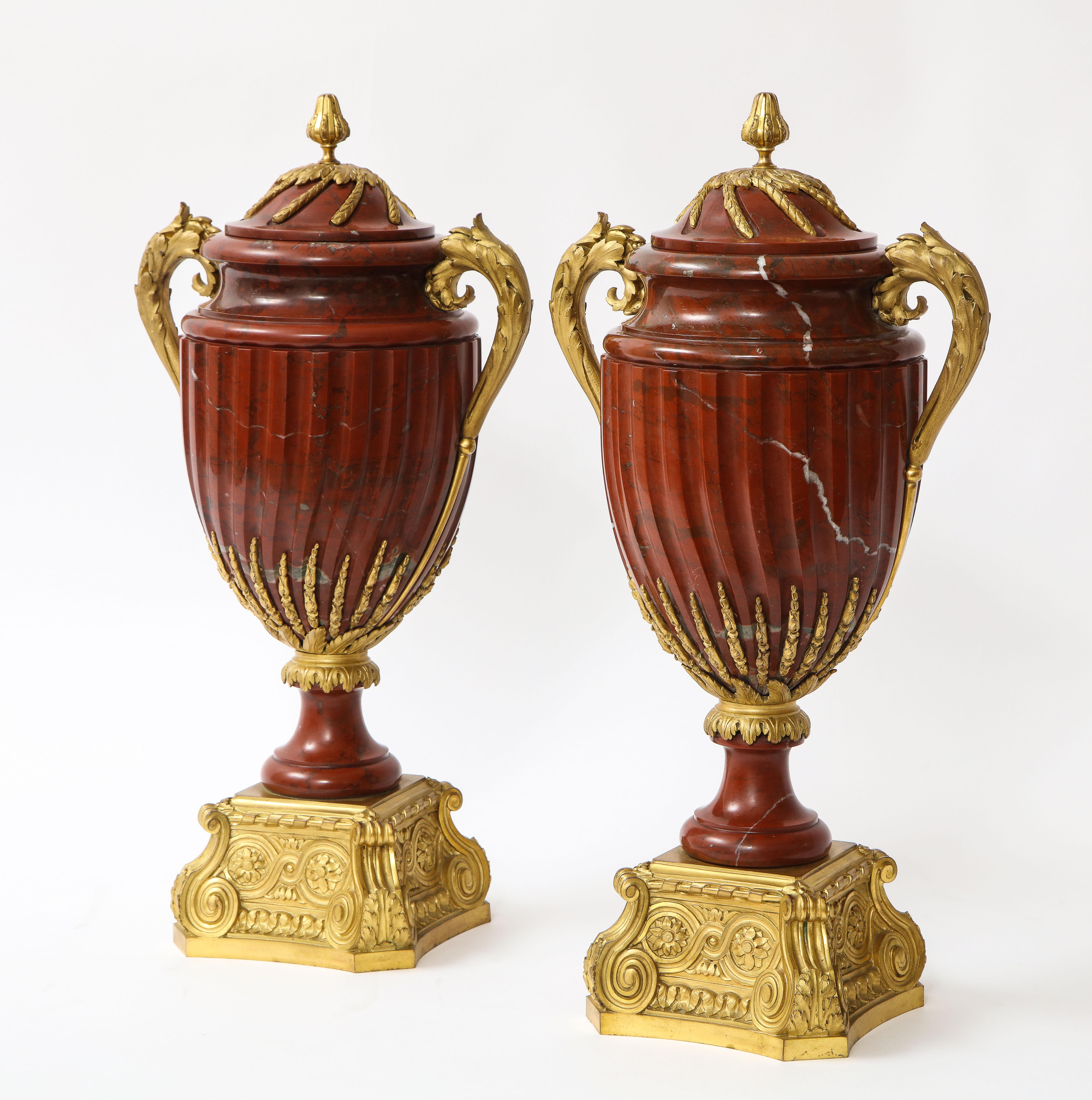 An elaborate pair of French 19th century Louis XVI style ormolu mounted rouge marble covered vases, signed MAISON BOUDET. Each of baluster form, mounted with ormolu acanthus leaf handles, the covers with ormolu vines attached to a circular acanthus