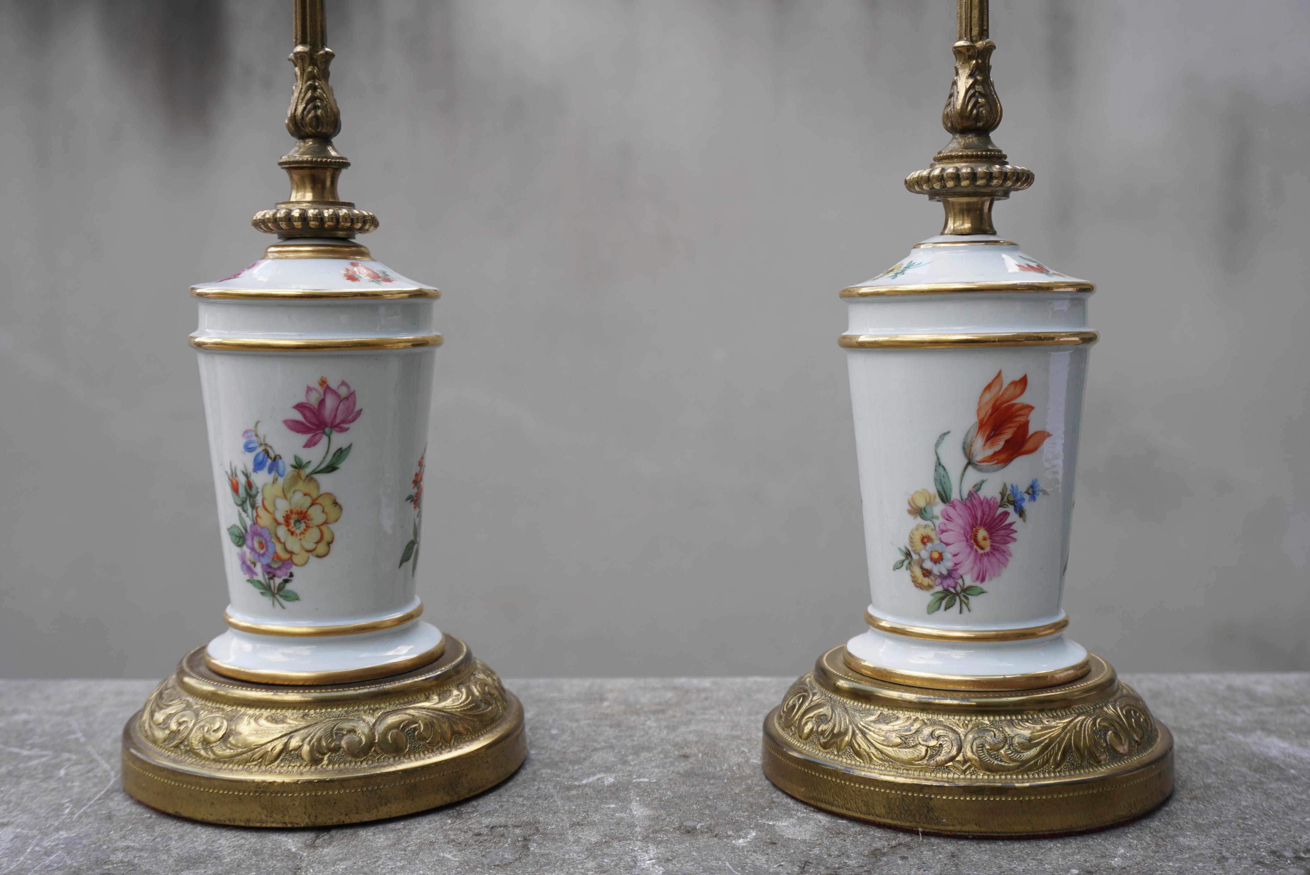 A pair porcelain brass and porcelain table lamps with flower decoration.

Height 13.7