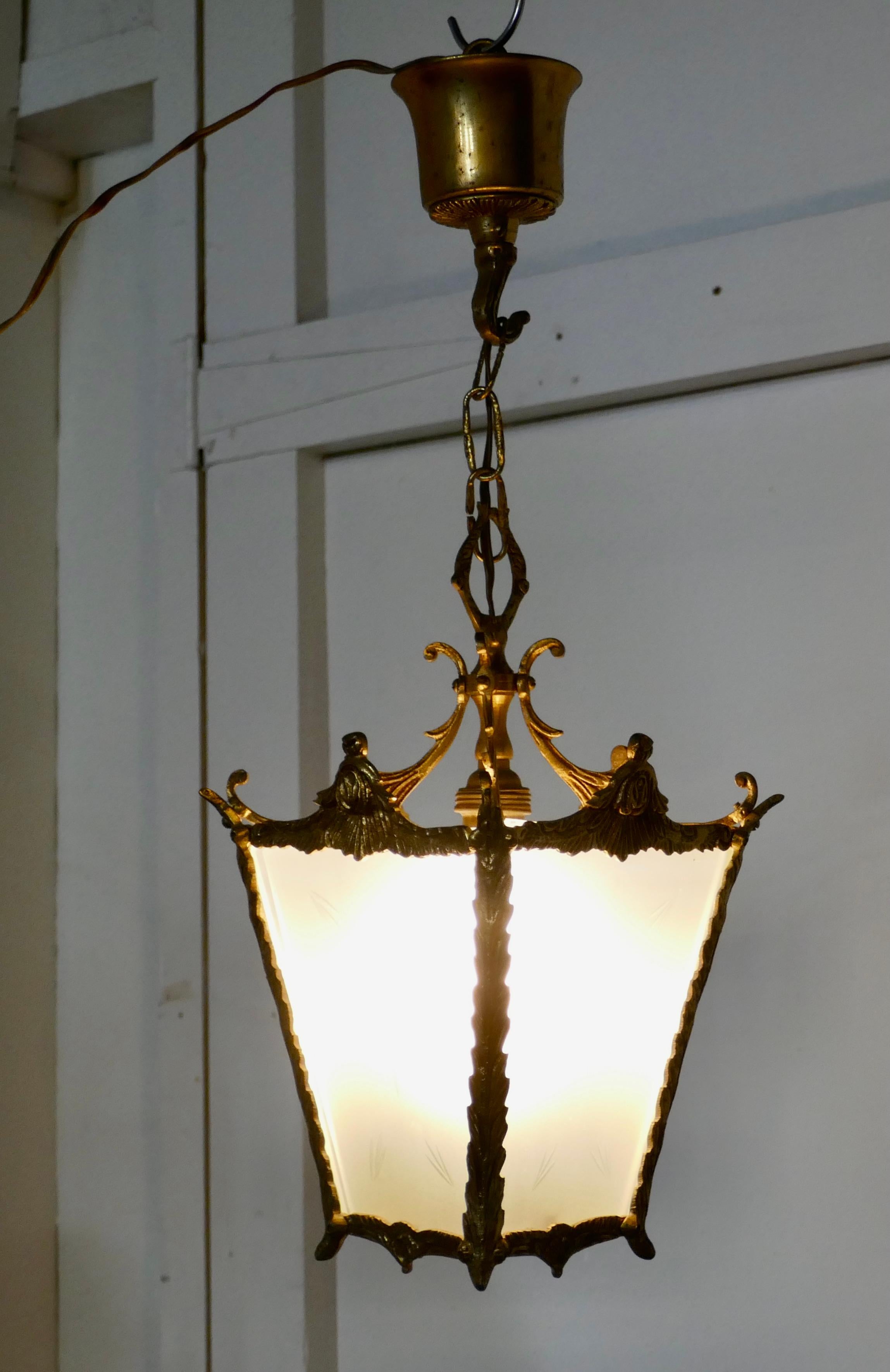 A Pair of French Rococo brass and etched glass hall lanterns 

This is a good quality pair, the lights have 4 Opaline glass panels which are etched with a starburst 

The lanterns are decorated in the French style with leaves and they hang from