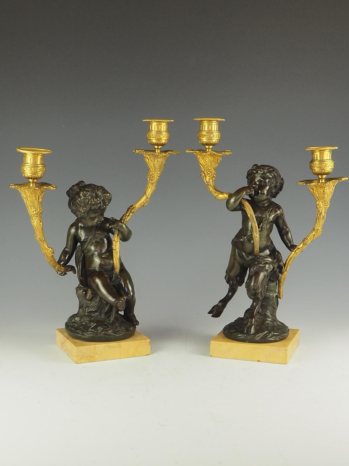 A very fine quality pair of French Louis XV inspired patinated and gilt bronze putti twin arm candelabra depicting Bacchanal figures.

Each bronze sculpture supports two gilded bronze candleholders and figures resting on a marble plinth

The