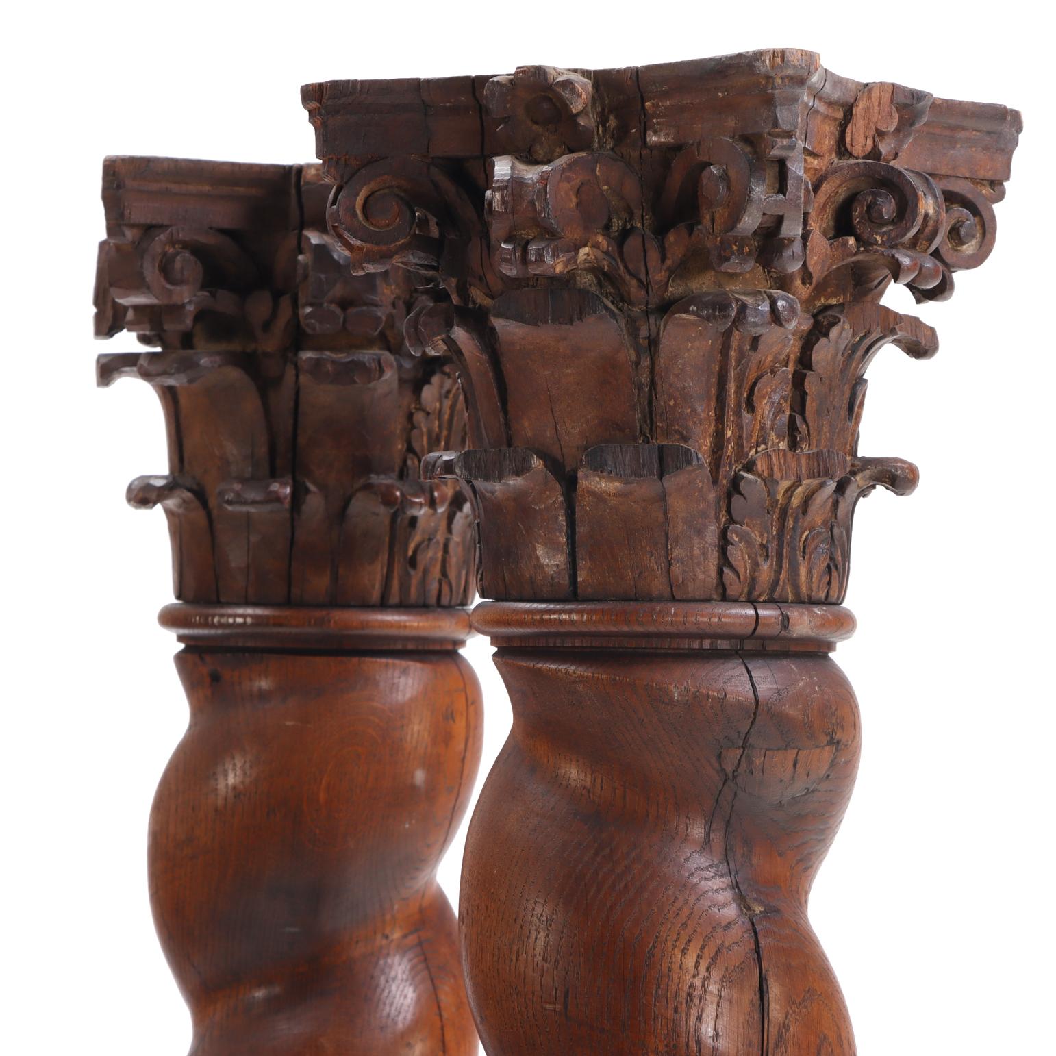 A handsome pair of French solid oak architectural columns retaining a warm patina and beautifully carved capitals. Each column features classic mid-19th-century proportions with squared bases and richly detailed carving on three sides of the